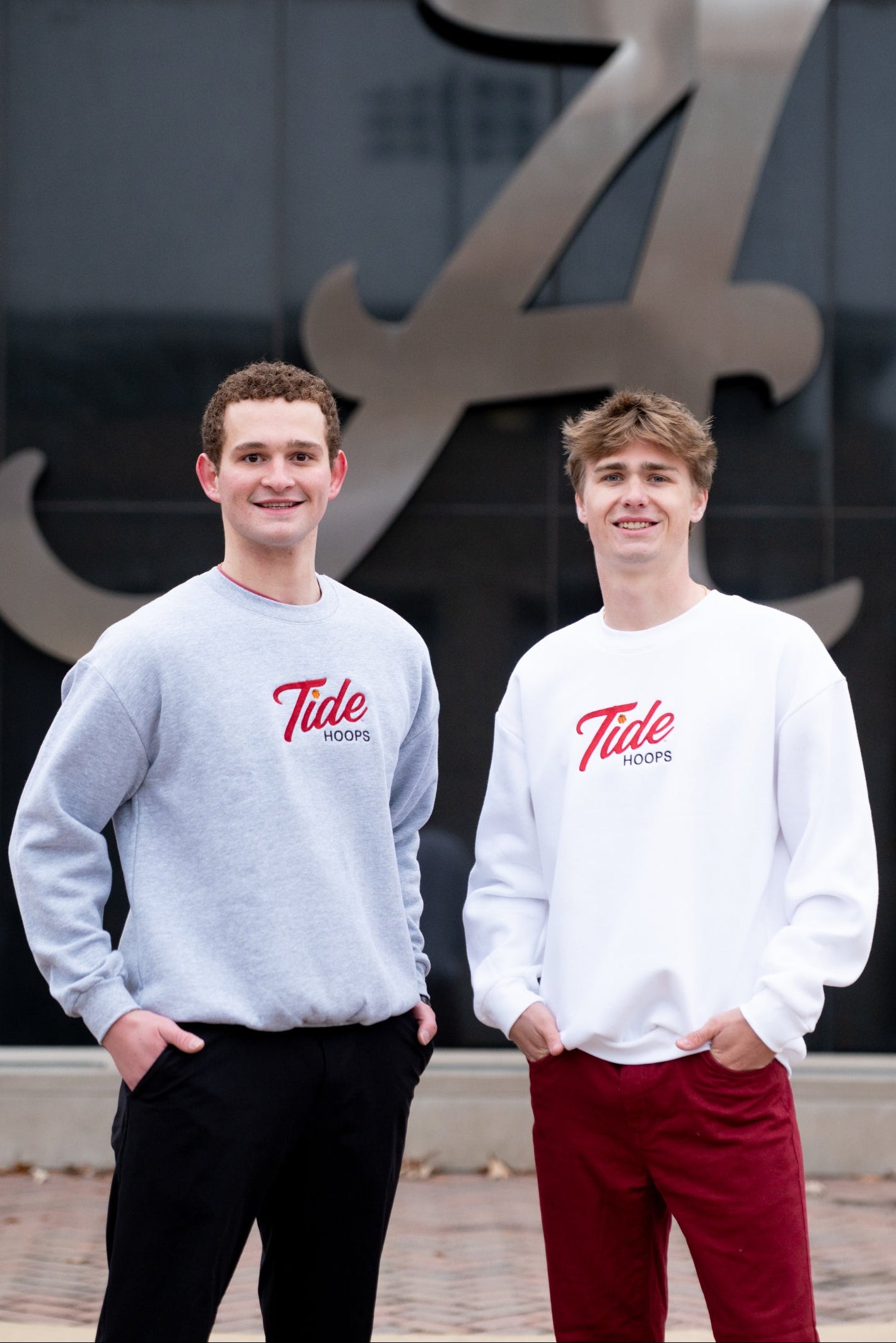 Two individuals wearing 'Tide' sweatshirts standing in front of a large 'A' logo.
