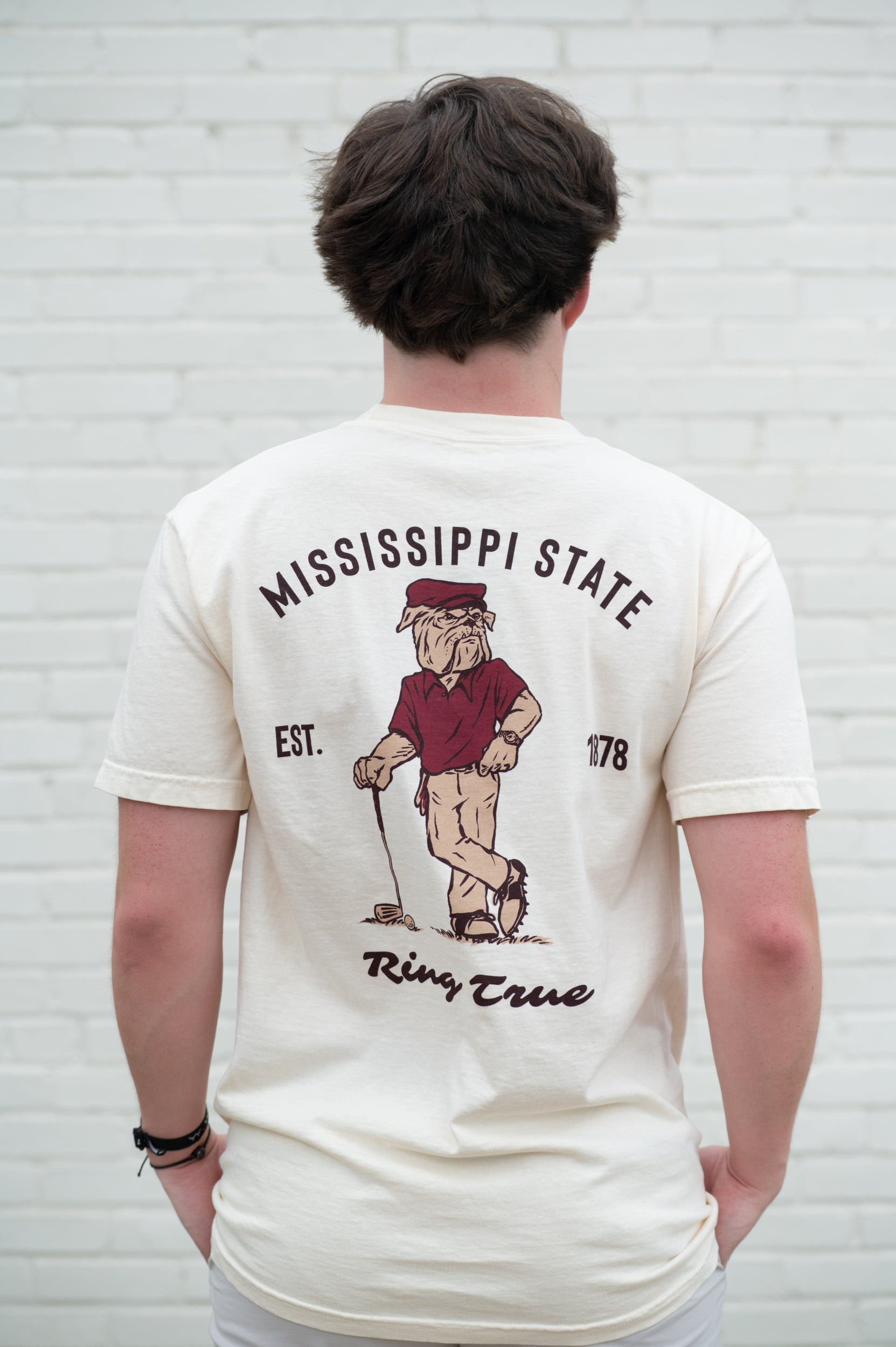 Mississippi State Ivory T-Shirt with an image of Bully leaning against a golf club between Maroon Text "Mississippi State" and "Ring True"