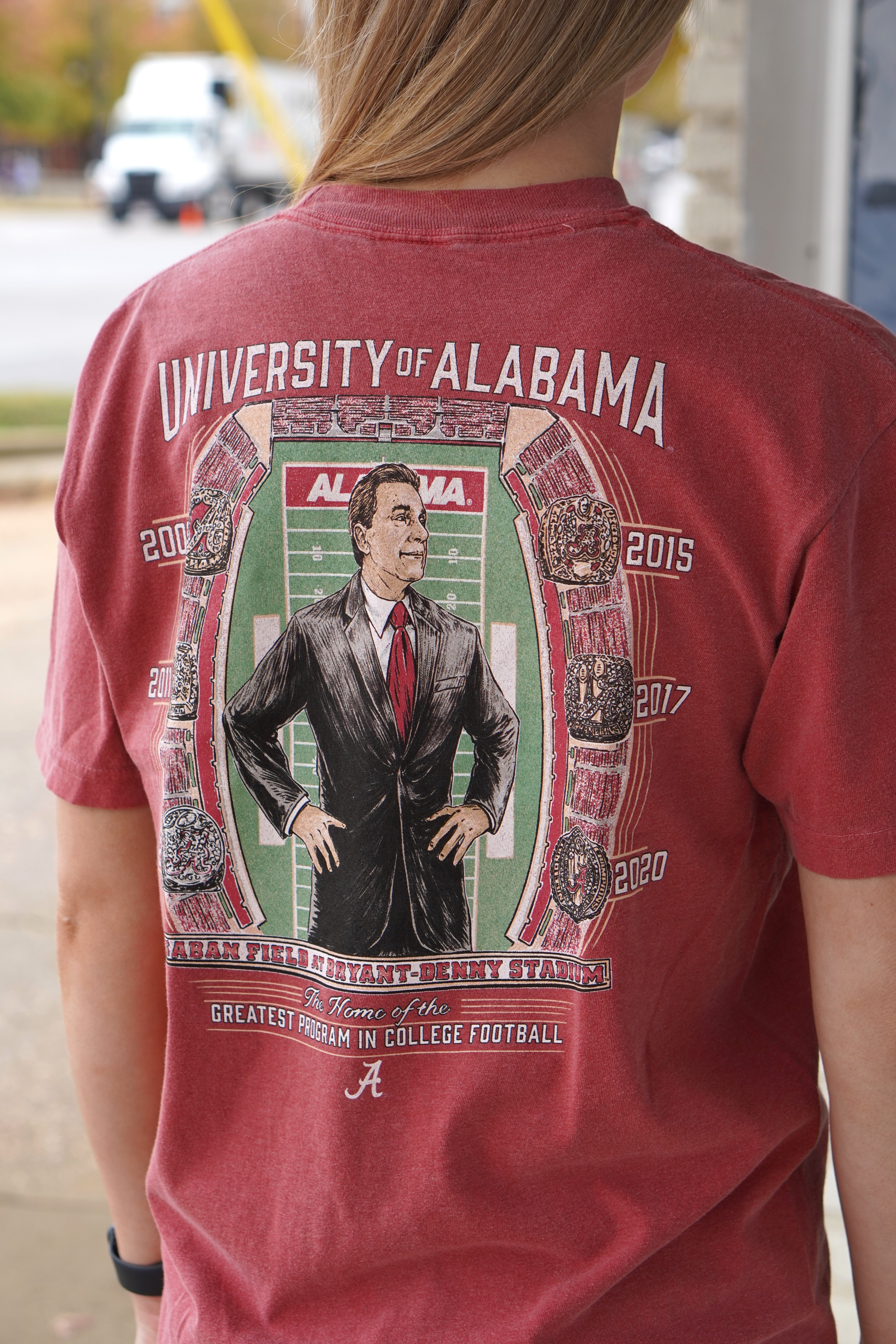 University of Alabama Champion Legacy at Saban Field Red Comfort Colors T-Shirt with an image of Nick Saban standing over Bryant-Denny Stadium surrounded by the years Alabama won the Football Championship