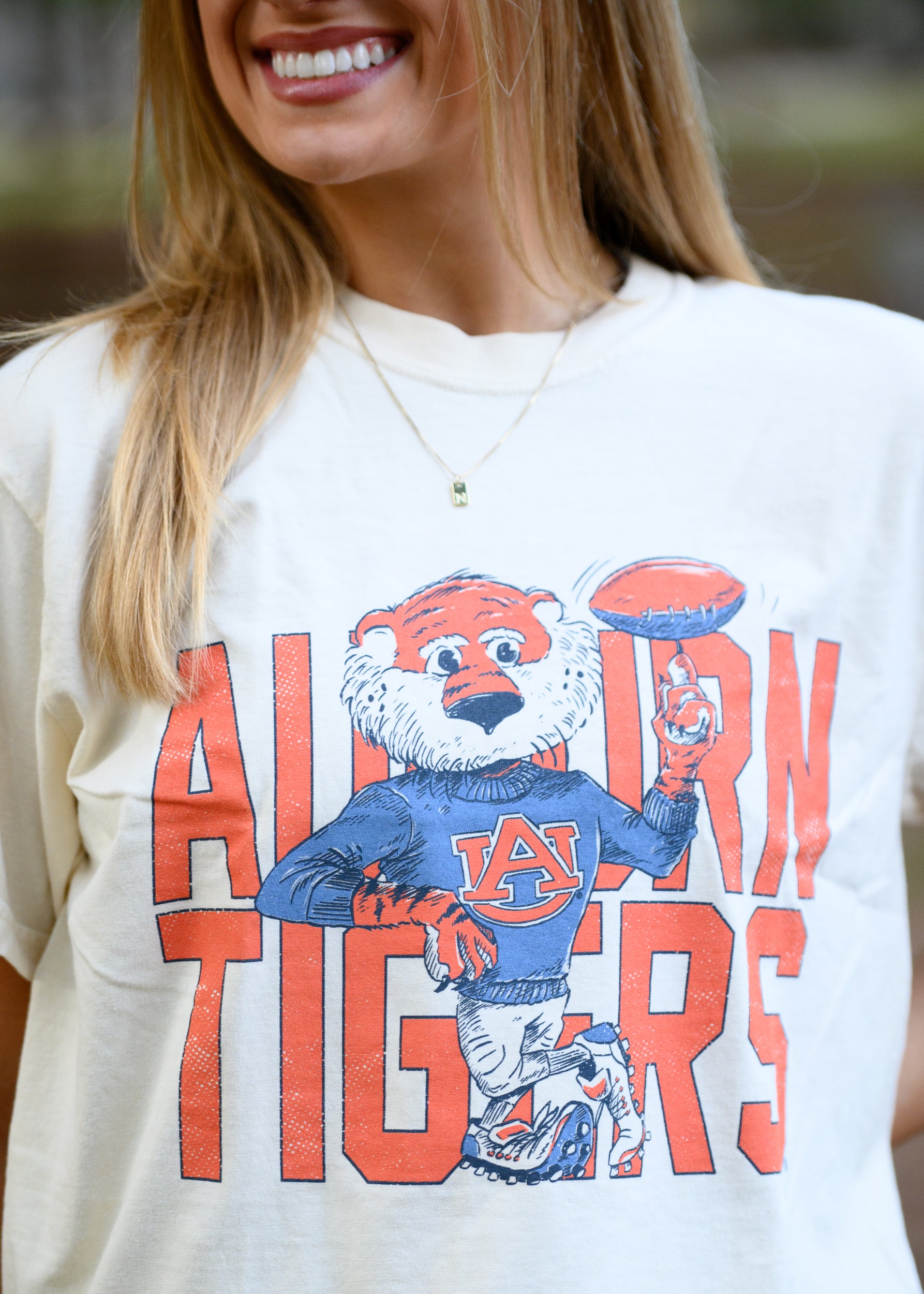 Auburn University Cream Chill Aubie Comfort Colors T-Shirt with Orange text "Auburn Tigers" and a graphic of Aubie leaning against the "G" of "Tigers"