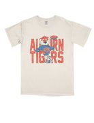 Auburn University Cream Chill Aubie Comfort Colors T-Shirt with Orange text "Auburn Tigers" and a graphic of Aubie leaning against the "G" of "Tigers"