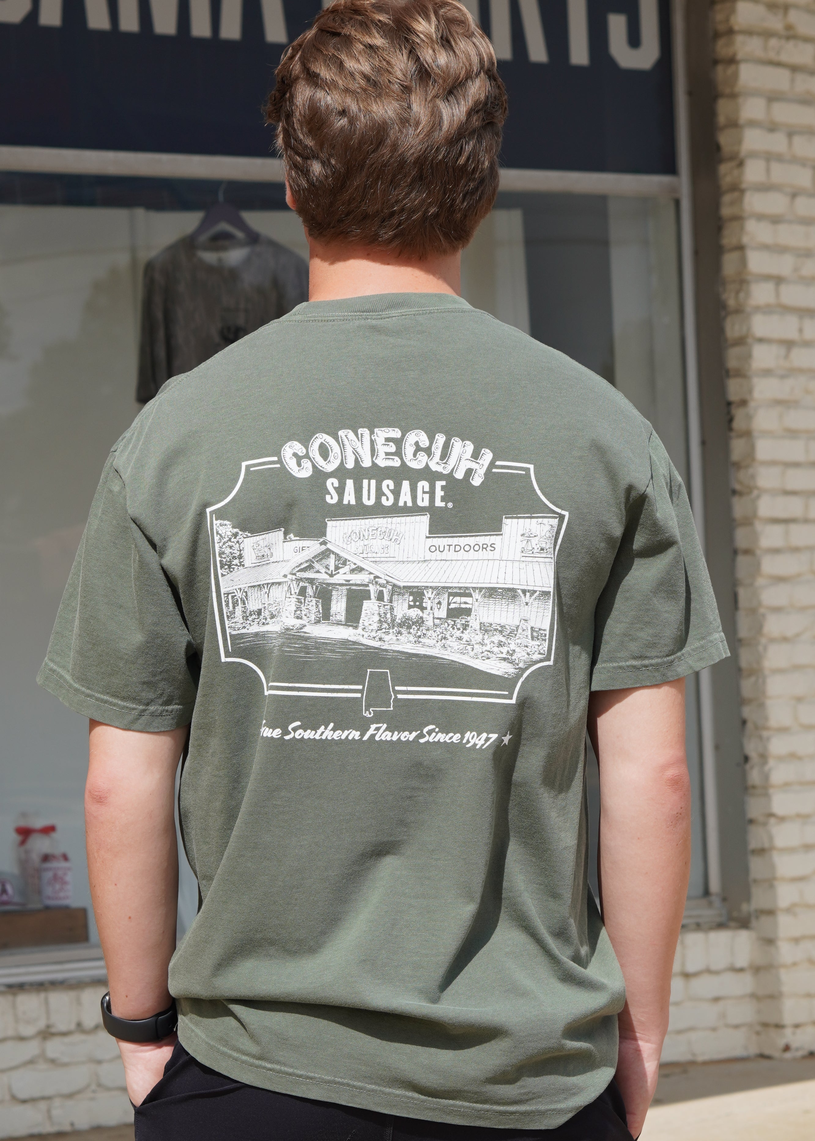 Conecuh Dark Green Shirt with an illustration of the old Conecuh Sausage building