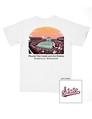 Mississippi State White T-Shirt with an image of the sun setting over the crowded Davis-Wade Stadium above text “Praise The Lord And Go Dawgs”