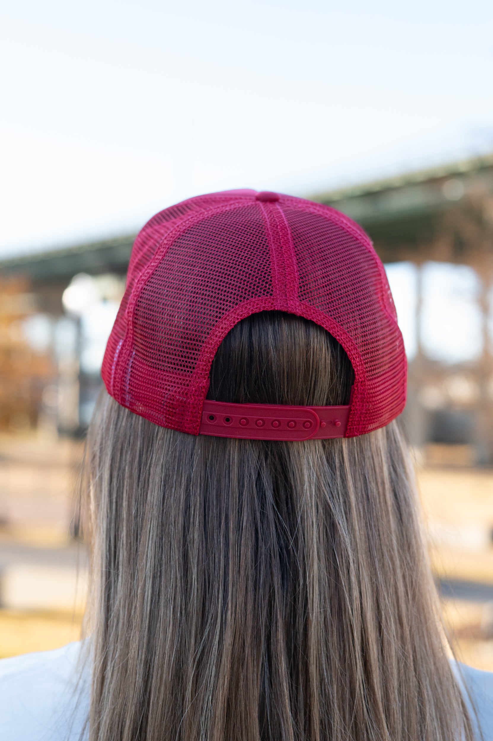 University of Alabama Red Trucker Hat with a patch featuring text “Dixieland” above and “Delight” below drawings of a cowboy boot, money, drink can, football, and playing card