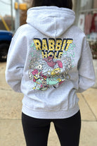 Grey Rabbit Hole Hoodie with marquee lights spelling "Rabbit Hole" lighting a band of Alice in Wonderland characters surrounded by paying cards