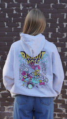 Grey Rabbit Hole Hoodie with marquee lights spelling "Rabbit Hole" lighting a band of Alice in Wonderland characters surrounded by paying cards