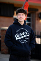 Gallettes Black Hoodie with a White Gallettes logo surrounded by White text "Home of the Yellow Hammer!" and "On the Strip- A Gameday Tradition"