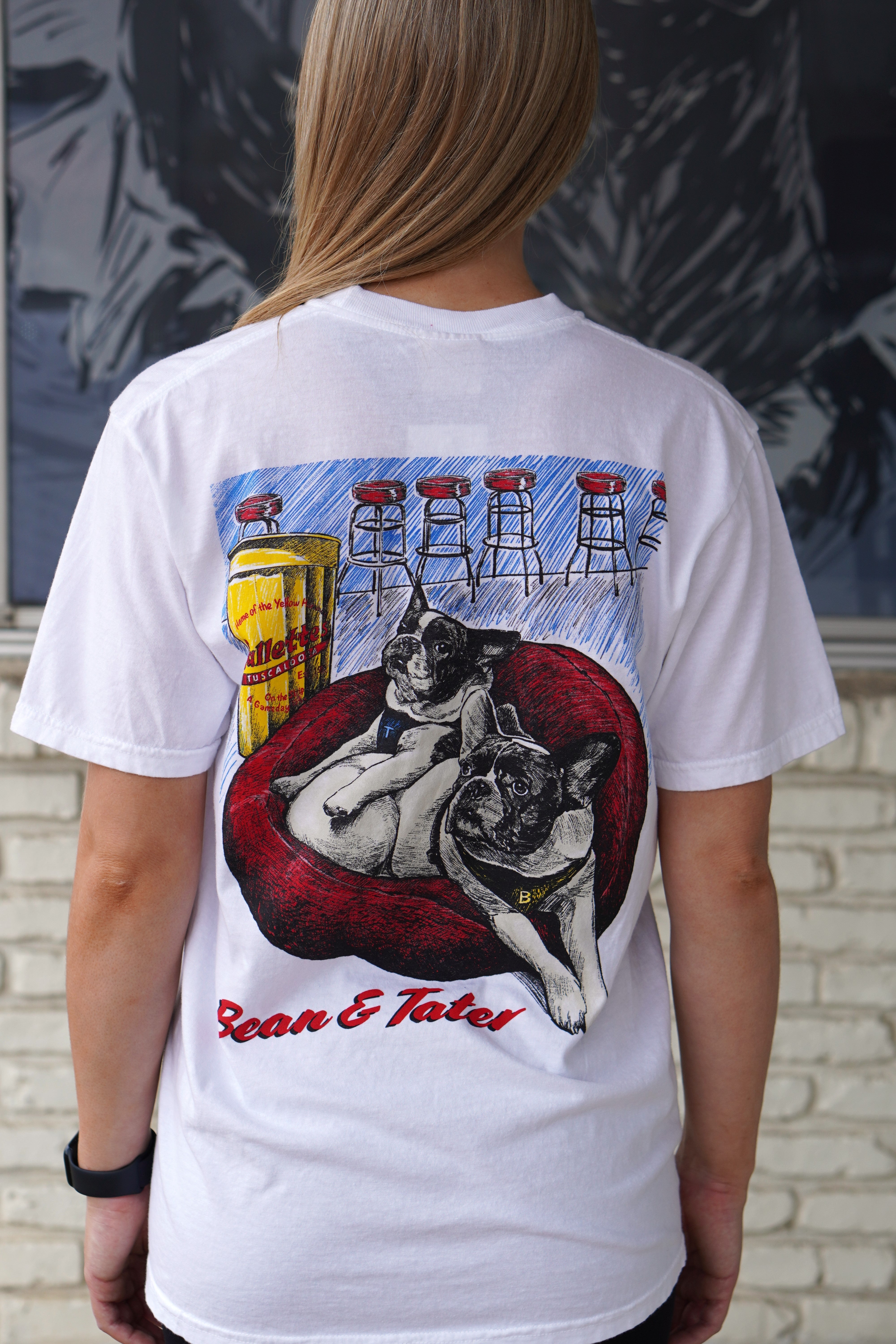 Gallettes White Tater and Bean T-Shirt with an illustration of two French bulldogs, Tater and Bean, laying down in a Red dog bed