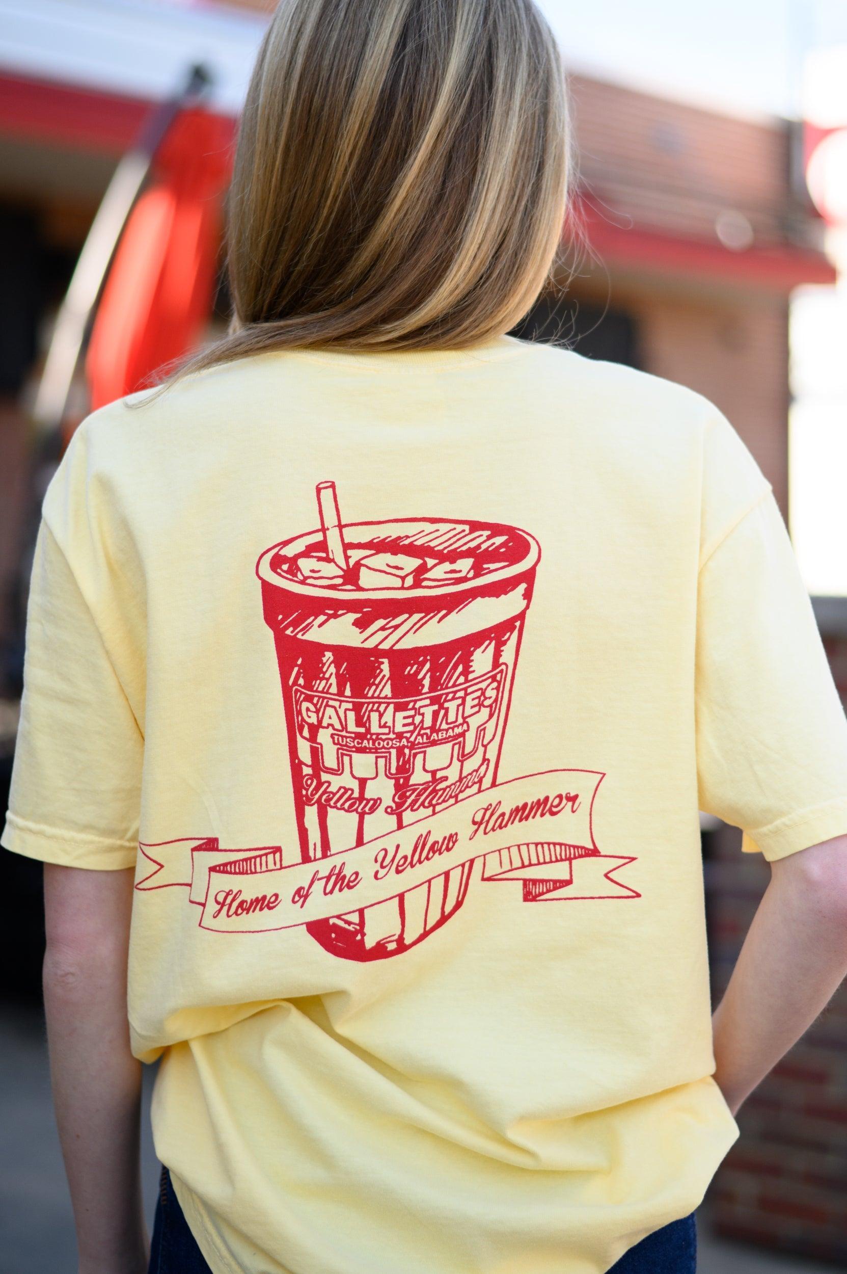 Gallettes Yellow T-Shirt with a Red illustration of a full Gallettes cup behind a banner with text "Home of the Yellow Hammer"