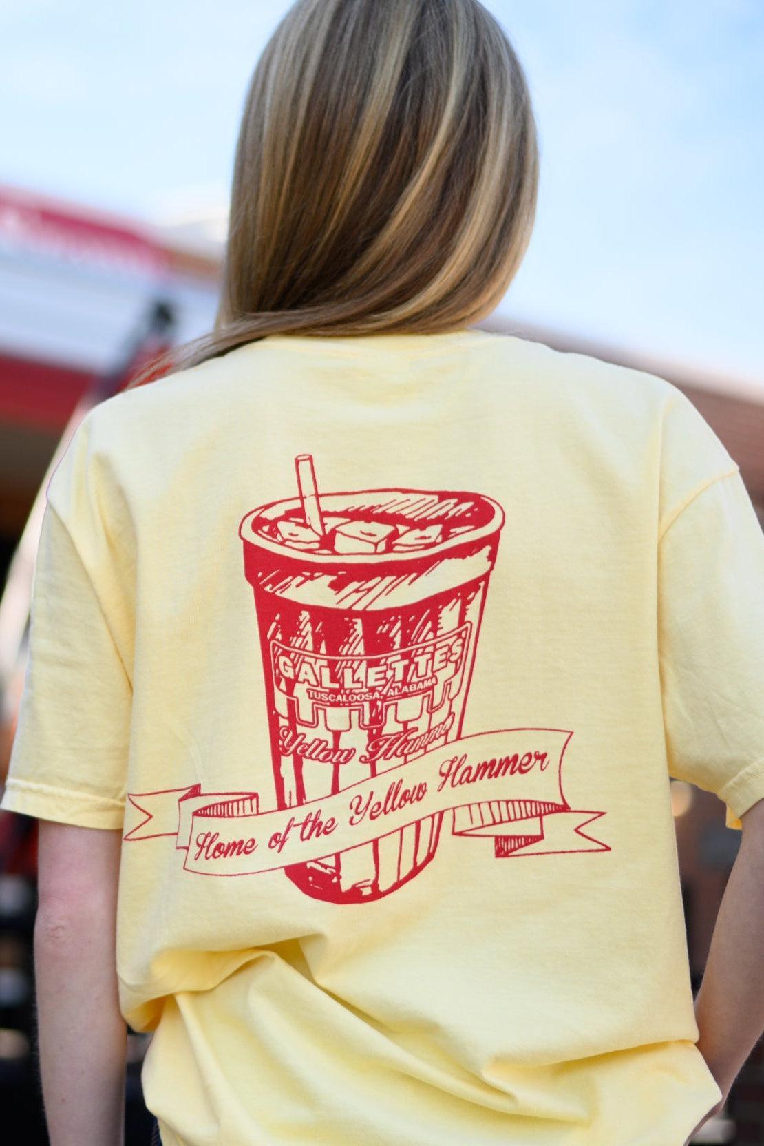 Gallettes Yellow T-Shirt with a Red illustration of a full Gallettes cup behind a banner with text "Home of the Yellow Hammer" and 
