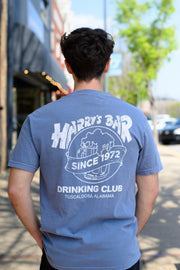 Harry’s Bar Blue T-Shirt with an image of an overflowing beer mug with a sash reading “Since 1972” above the text “Drinking Club”