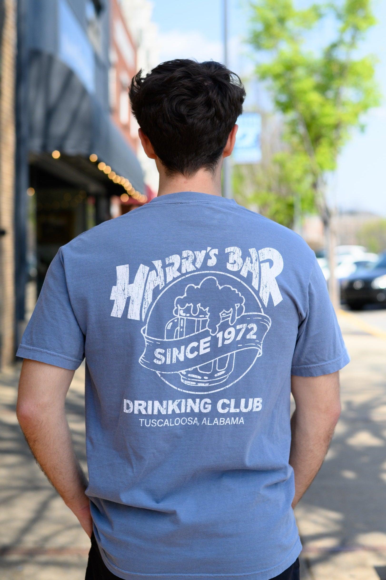 Harry’s Bar Blue T-Shirt with an image of an overflowing beer mug with a sash reading “Since 1972” above the text “Drinking Club”