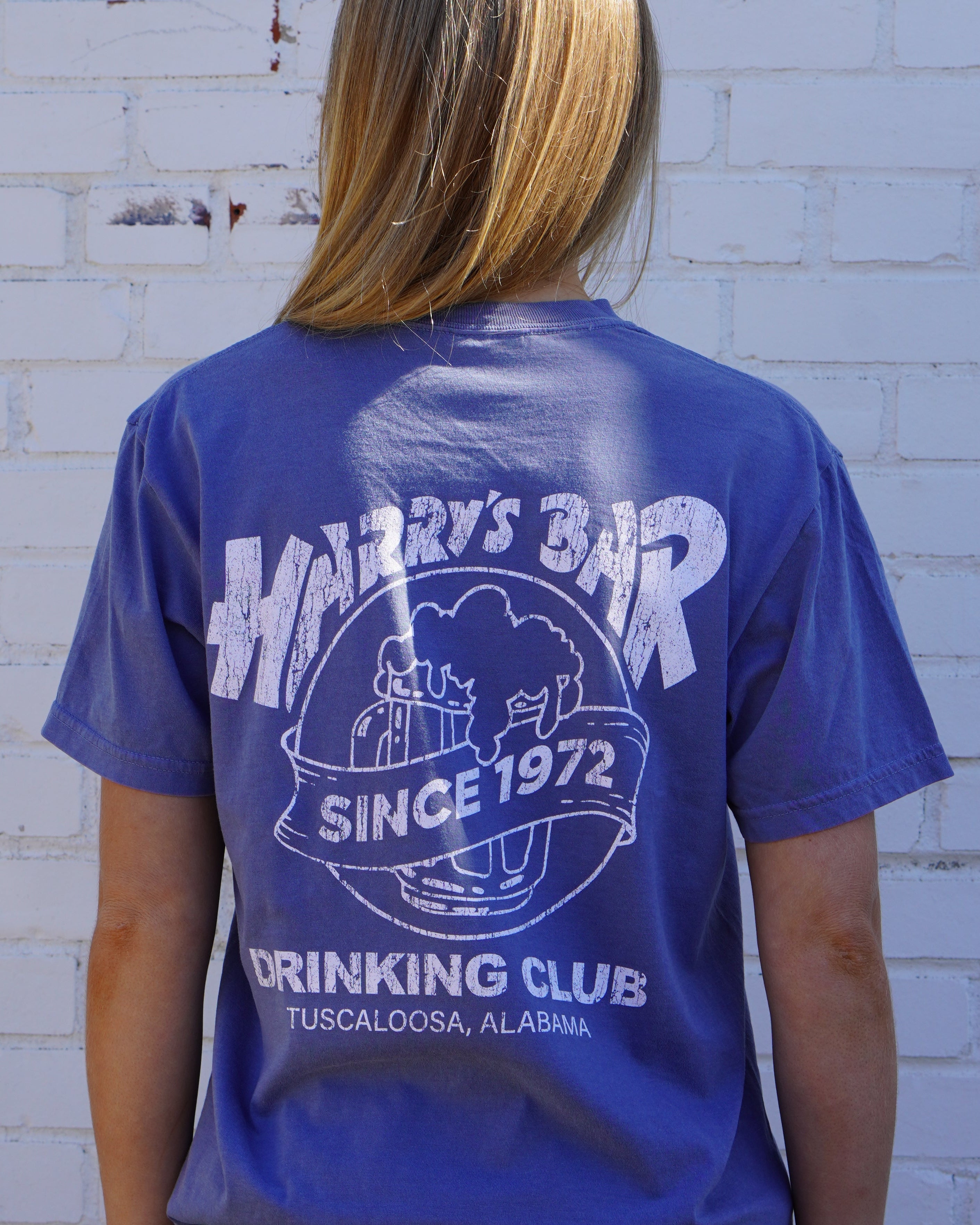 Harry’s Bar Blue T-Shirt with an image of an overflowing beer mug with a sash reading “Since 1972” above the text “Drinking Club”