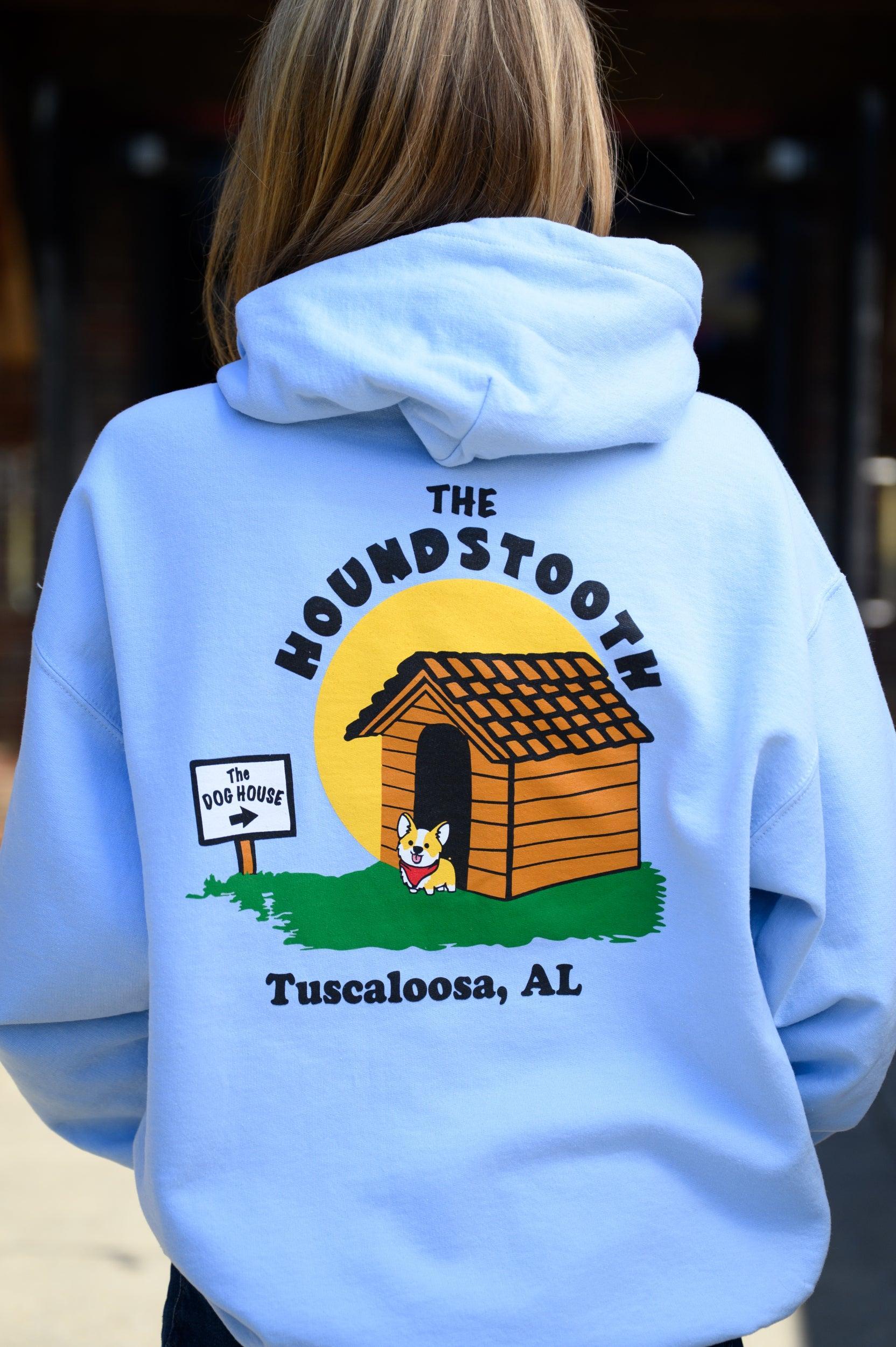 The Houndstooth Light Blue Hoodie with Black text "The Houndstooth" above an image of a corgi standing outside of a doghouse