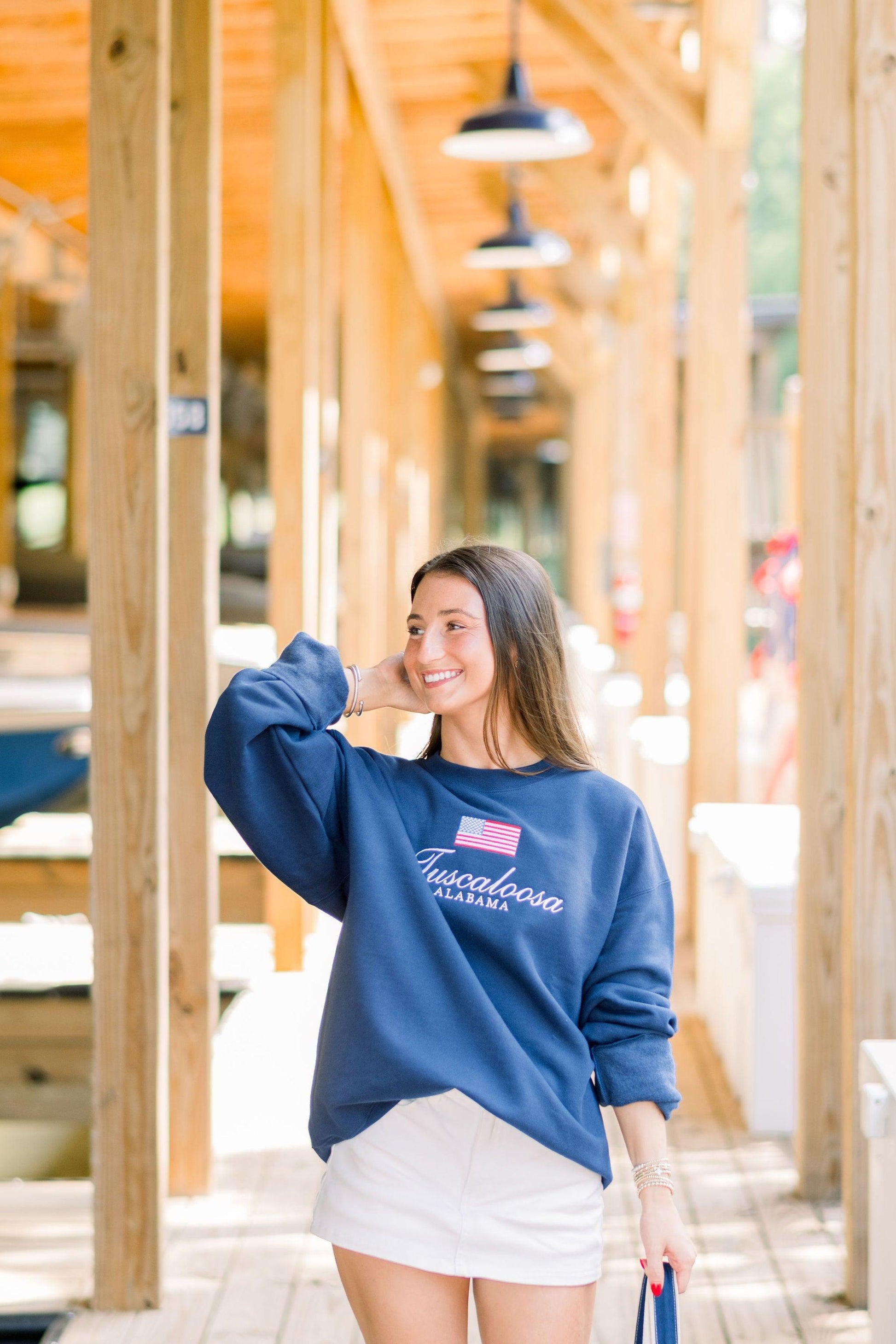 Local Merch Navy Crewneck with an embroidered American Flag above White embroidered text “Tuscaloosa Alabama”
