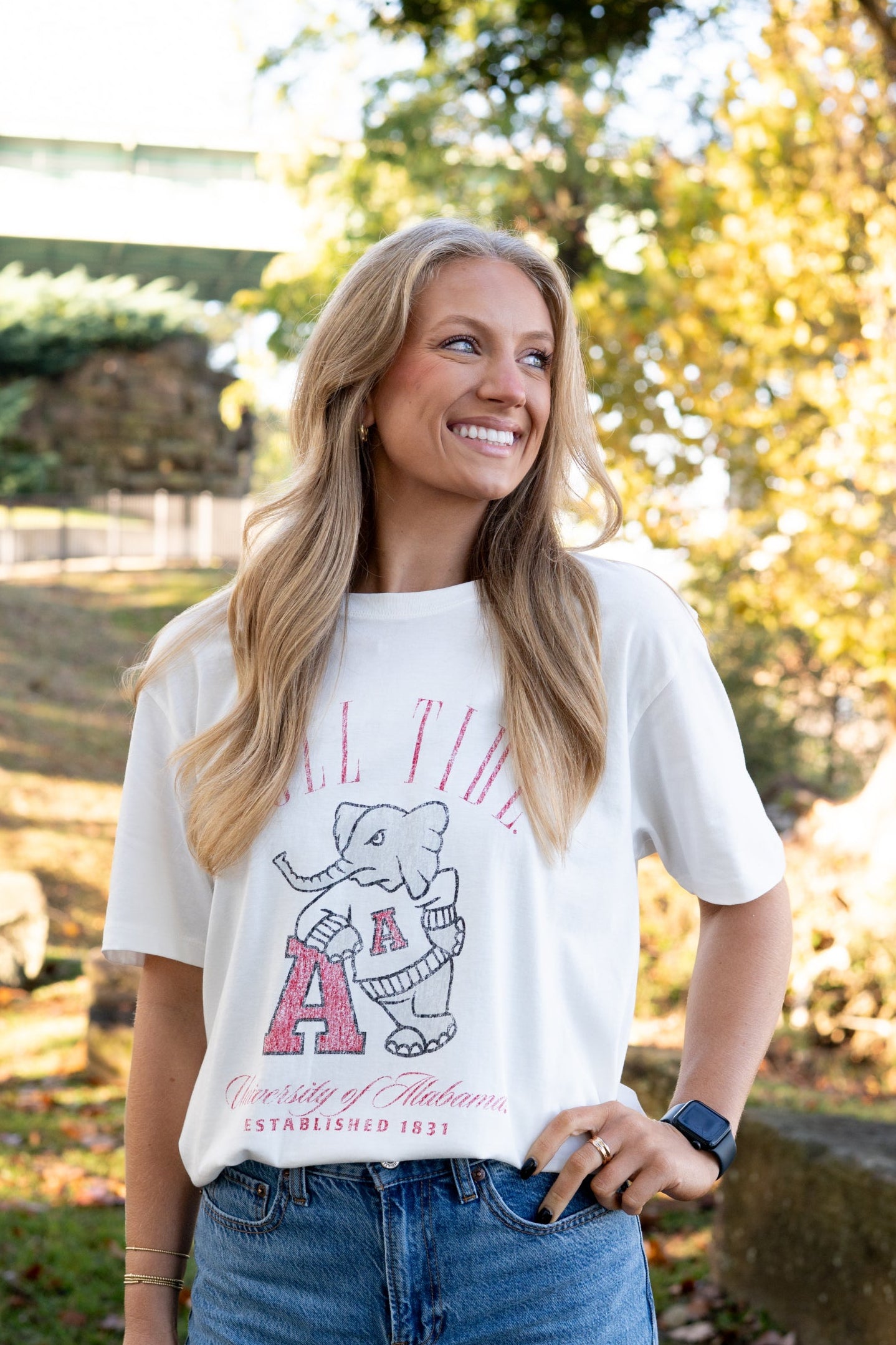 University of Alabama Ivory T-Shirt with Red text “Roll Tide” above an image of Big Al leaning on a Black A