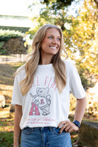 University of Alabama Ivory T-Shirt with Red text “Roll Tide” above an image of Big Al leaning on a Black A