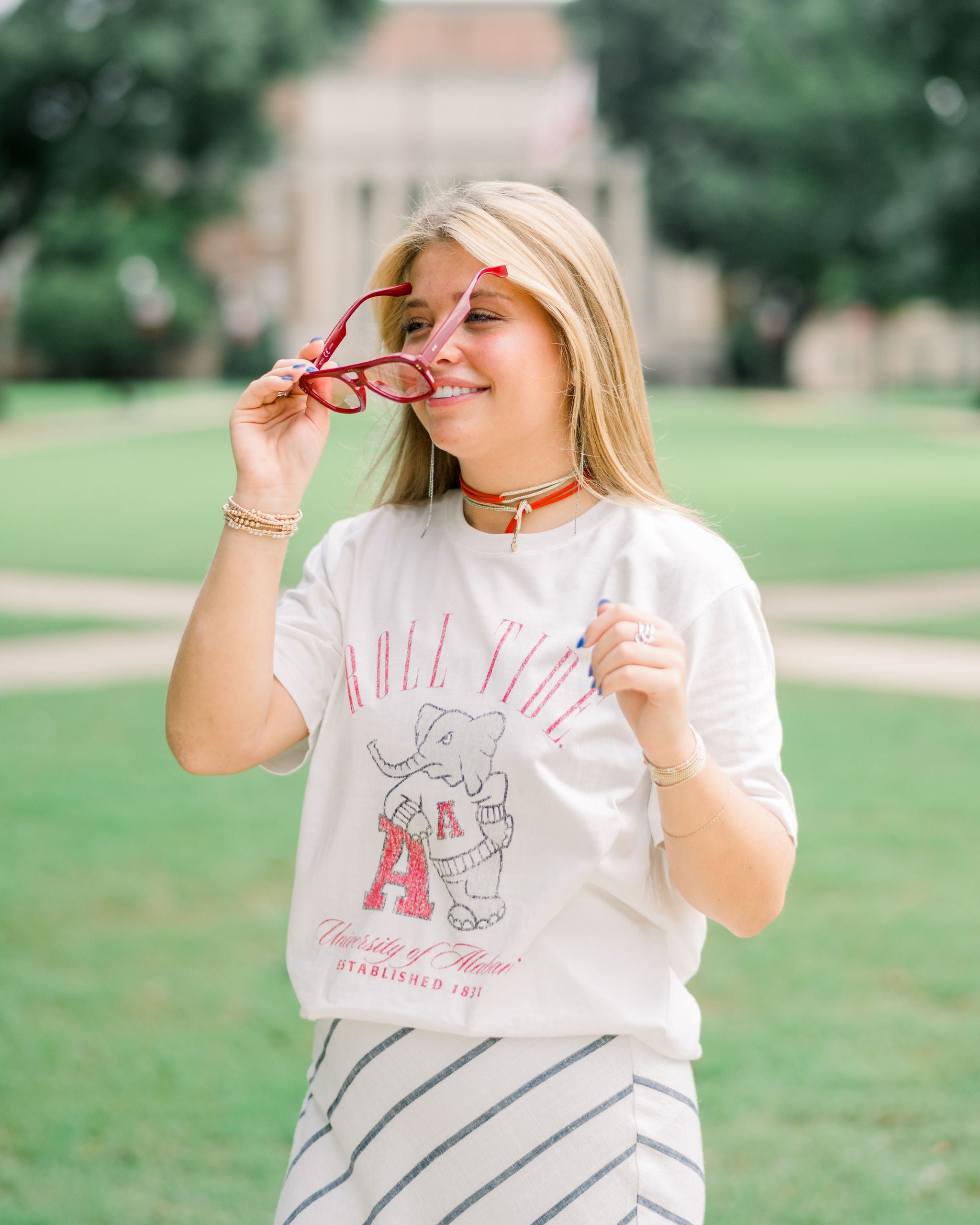 University of Alabama Ivory T-Shirt with Red text “Roll Tide” above an image of Big Al leaning on a Black A