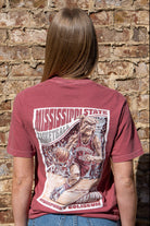 Mississippi State Crimson T-Shirt with a basketball card style design featuring Bully dribbling a basketball down the court in between text “Mississippi State Basketball” and “The Hump Humphrey Coliseum”