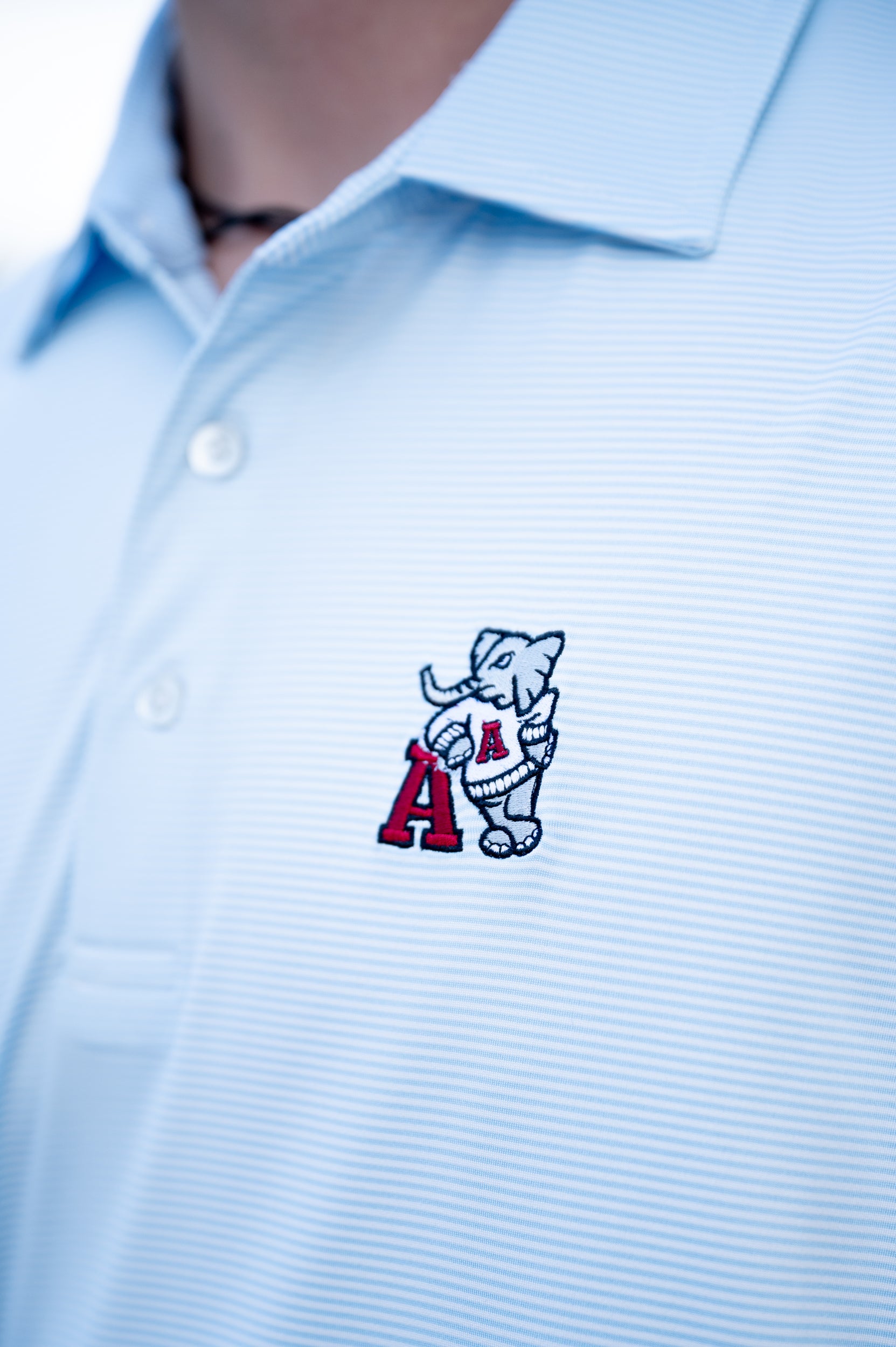 University of Alabama Light Blue Men’s Stripe Polo with embroidery of Big Al leaning on a Red Block A
