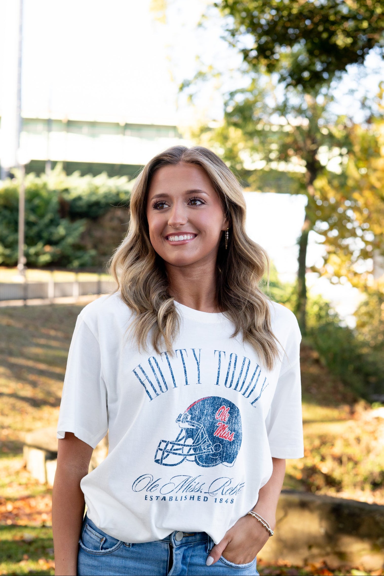 Ole Miss Ivory T-Shirt with Blue text “Hotty Toddy” above an image of a football helmet
