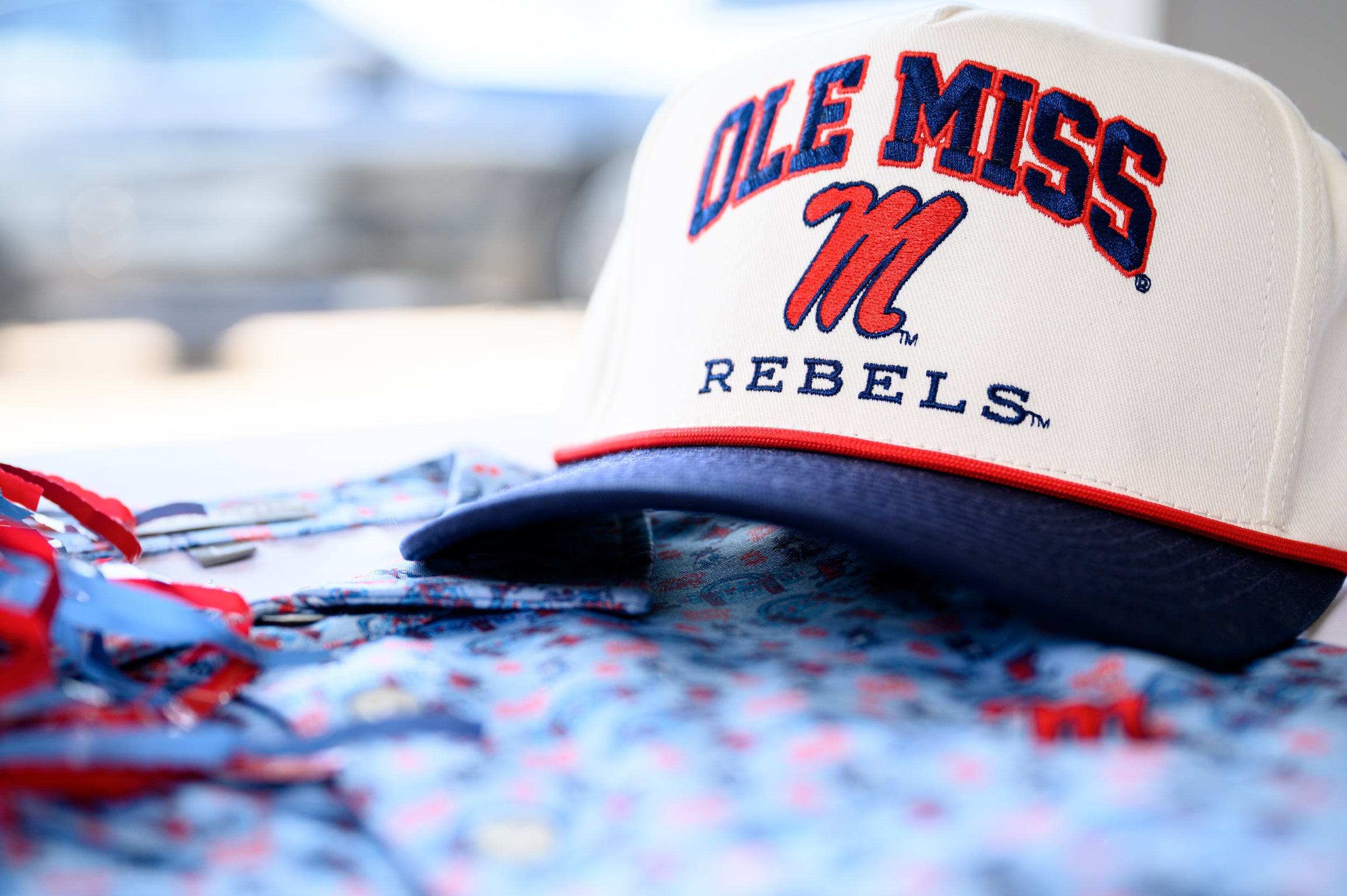 Ole Miss Cream and Navy Hat with embroidered text “Ole Miss Rebels” surrounding the Script M Logo