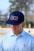 Ole Miss Navy Snapback Hat featuring a White patch with Navy “REBS” embroidery