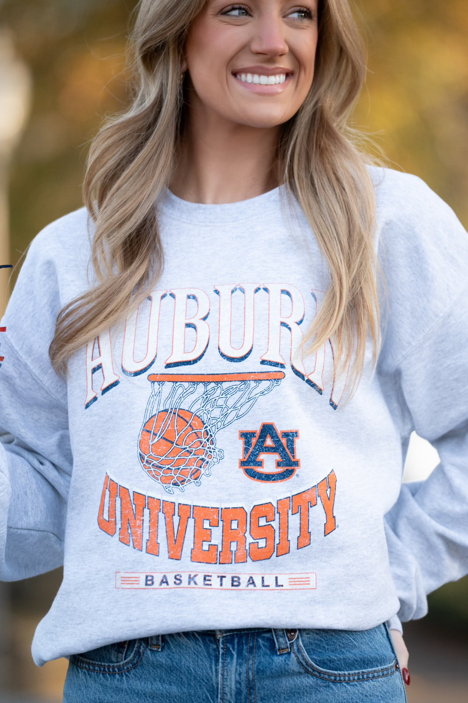 Auburn University Light Grey Heather Sweatshirt with a basketball landing in a hoop between text “Auburn” and “University Basketball” 