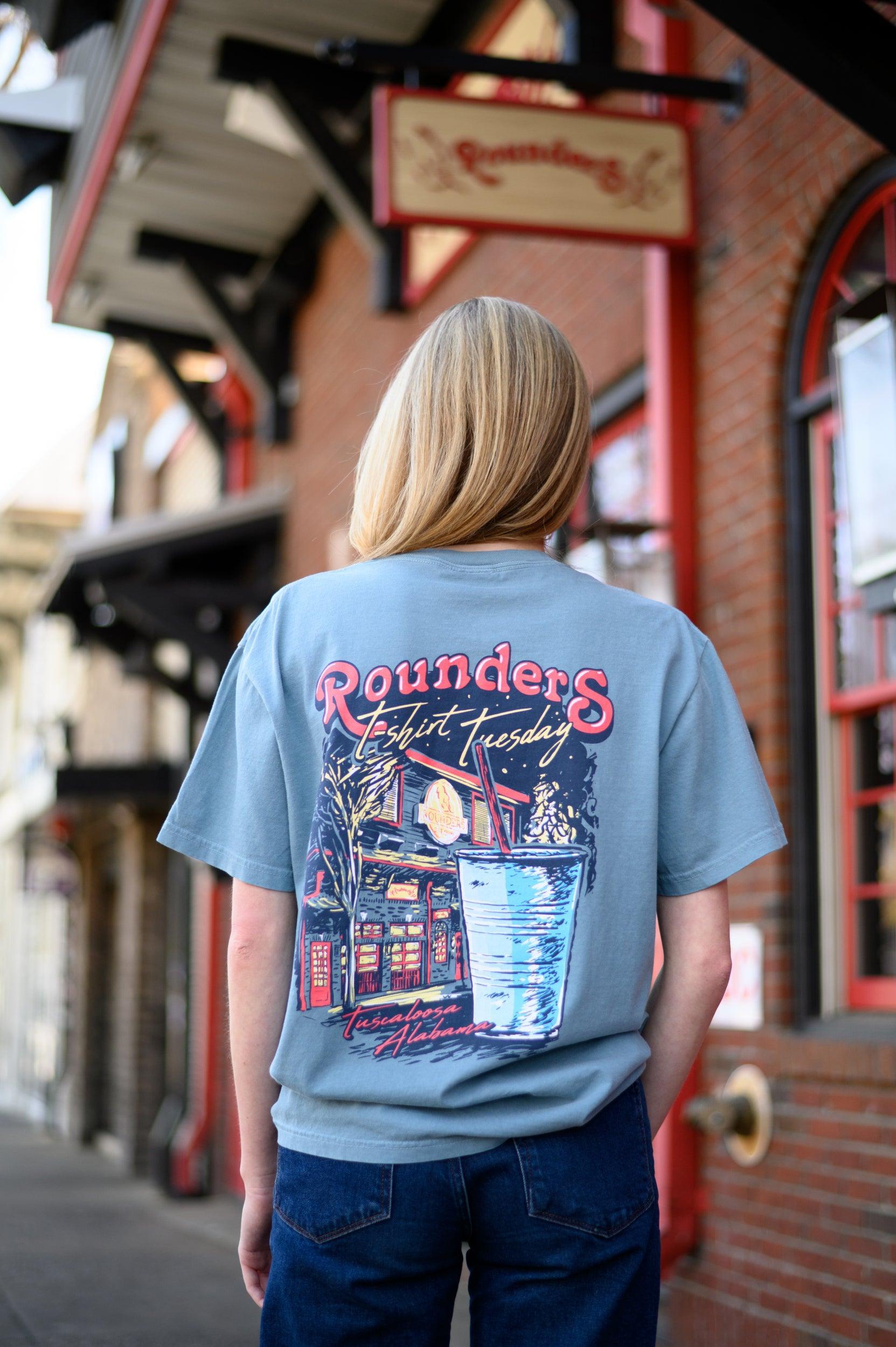 Rounders Blue T-Shirt with text "Rounders T-shirt Tuesday" above the Rounders Building and a Blue drink