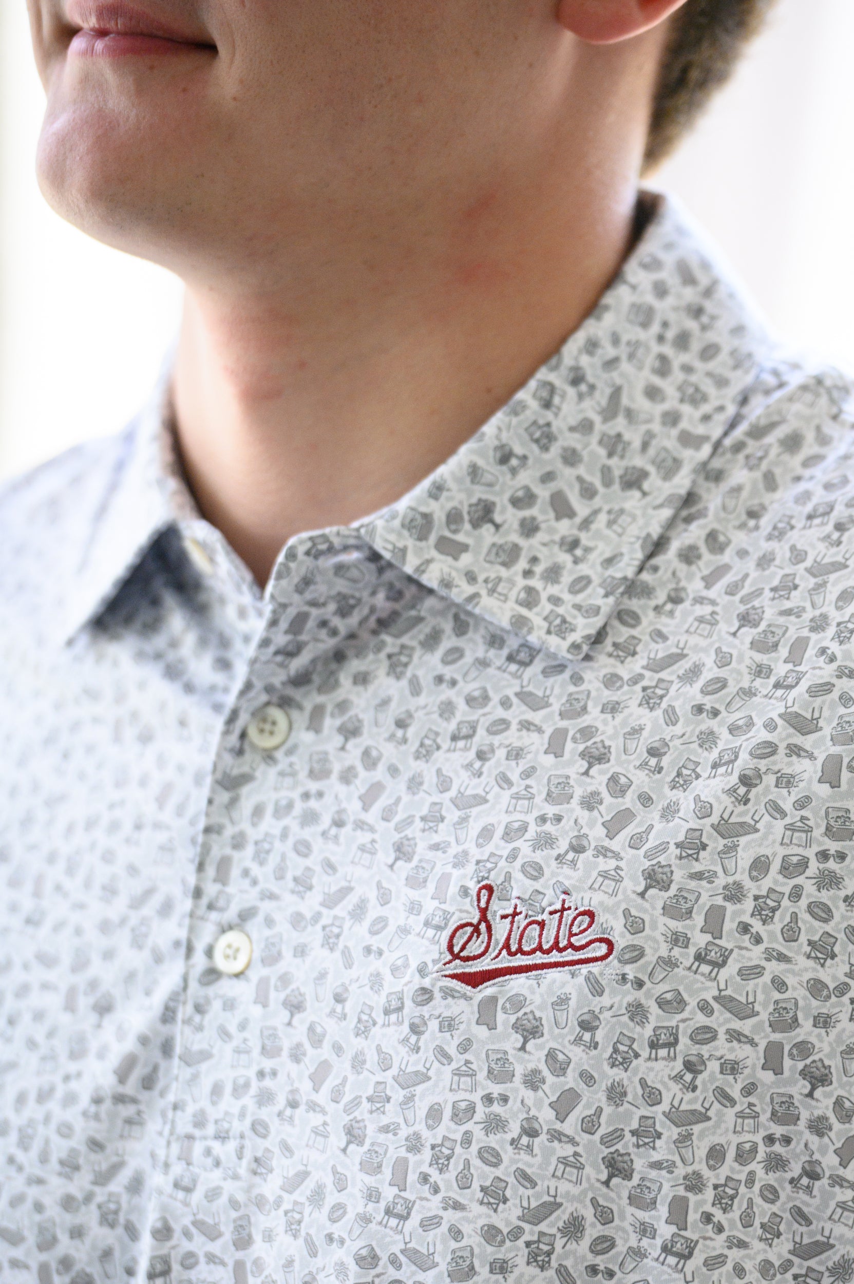 Mississippi State Grey Men’s Patterned Polo with a tailgate themed pattern and the Script State Logo embroidery