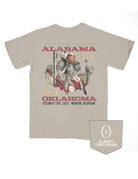 University of Alabama Beige T-Shirt with text “CFF First Round Alabama 34” above an image of Big Al in a cowboy outfit inside of an outline of the United States of America with text “24 Oklahoma December 19th, 2025; Norman, Oklahoma” below the image