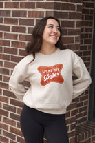 University of Alabama Bone Ladies' Crewneck featuring a Red sign with White text "Spend My Dollar"