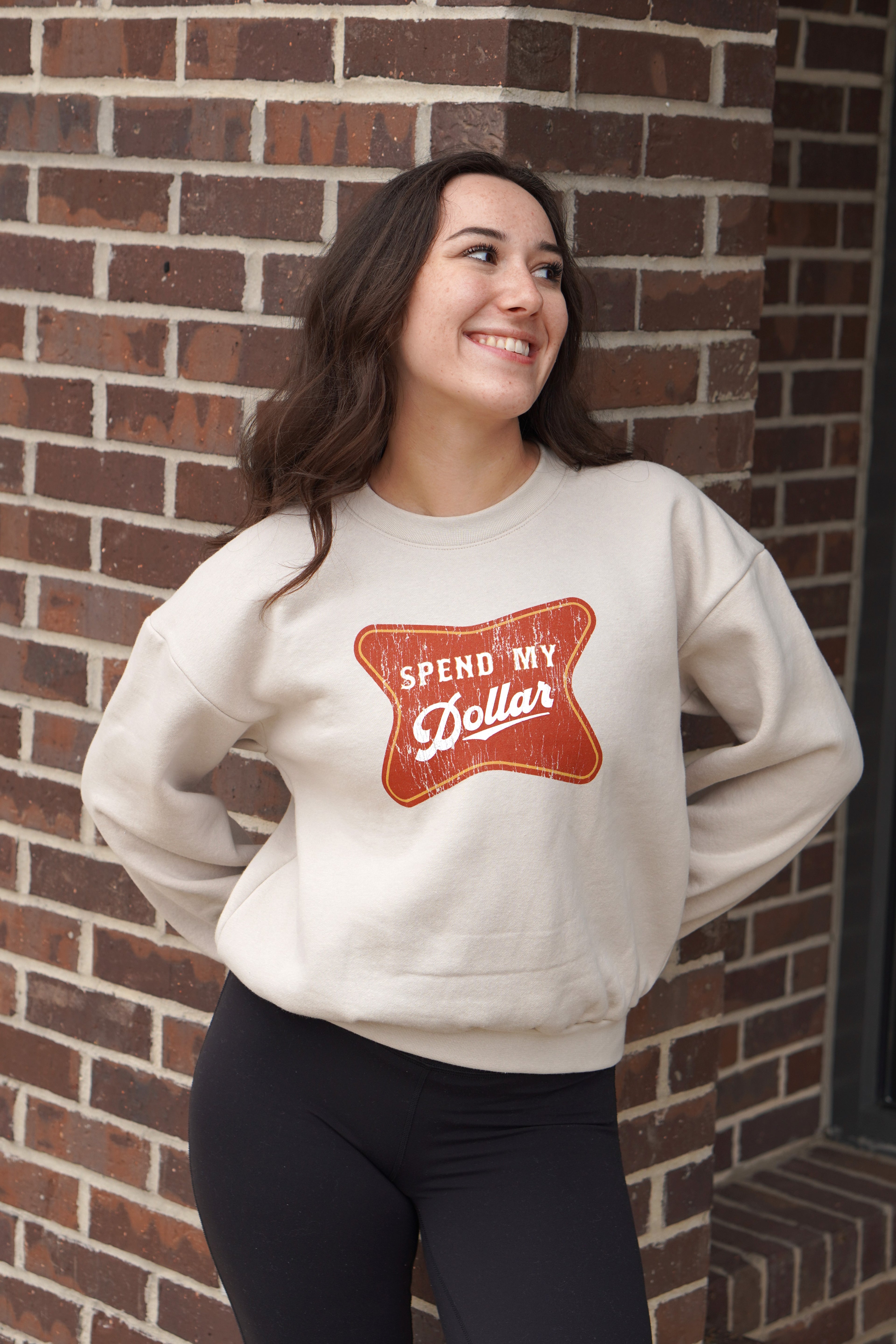 University of Alabama Bone Ladies' Crewneck featuring a Red sign with White text "Spend My Dollar"