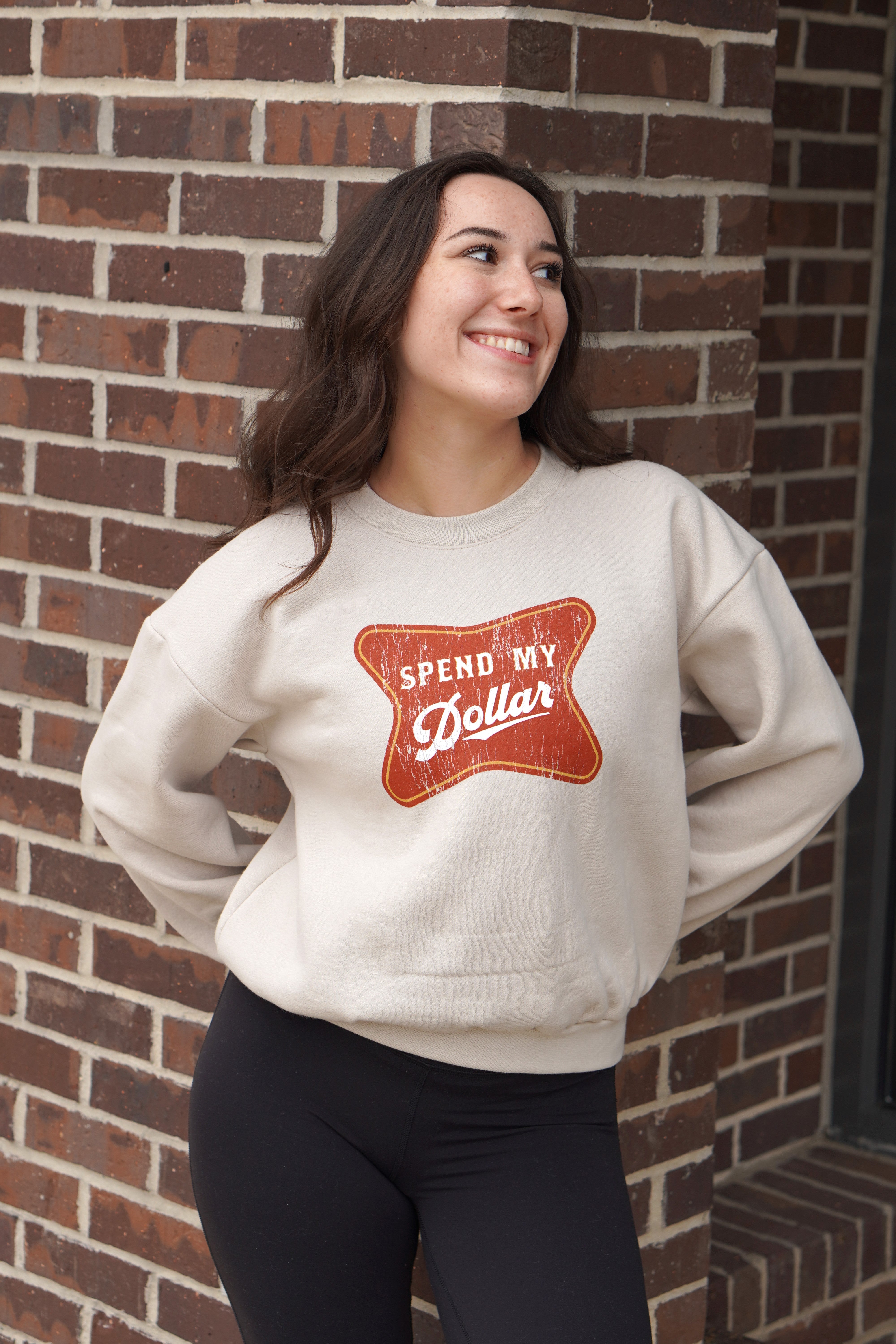 University of Alabama Bone Ladies' Crewneck featuring a Red sign with White text "Spend My Dollar"