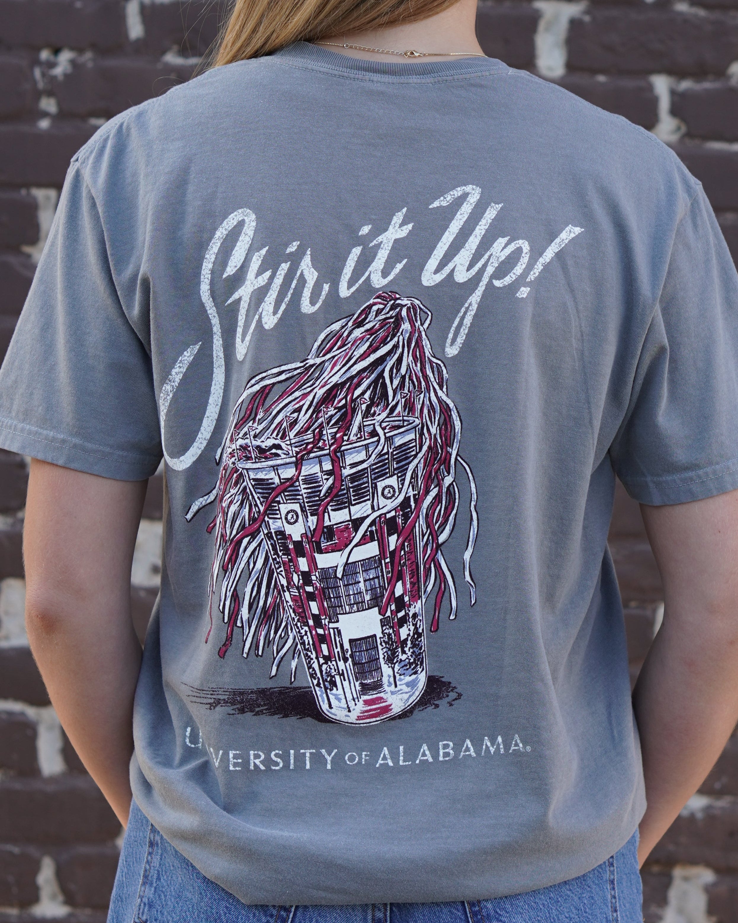 University of Alabama Grey T-Shirt with White text “Stir it Up!” above a stadium cup with a Red and White shaker inside 