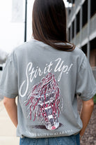 University of Alabama Grey T-Shirt with White text “Stir it Up!” above a stadium cup with a Red and White shaker inside 
