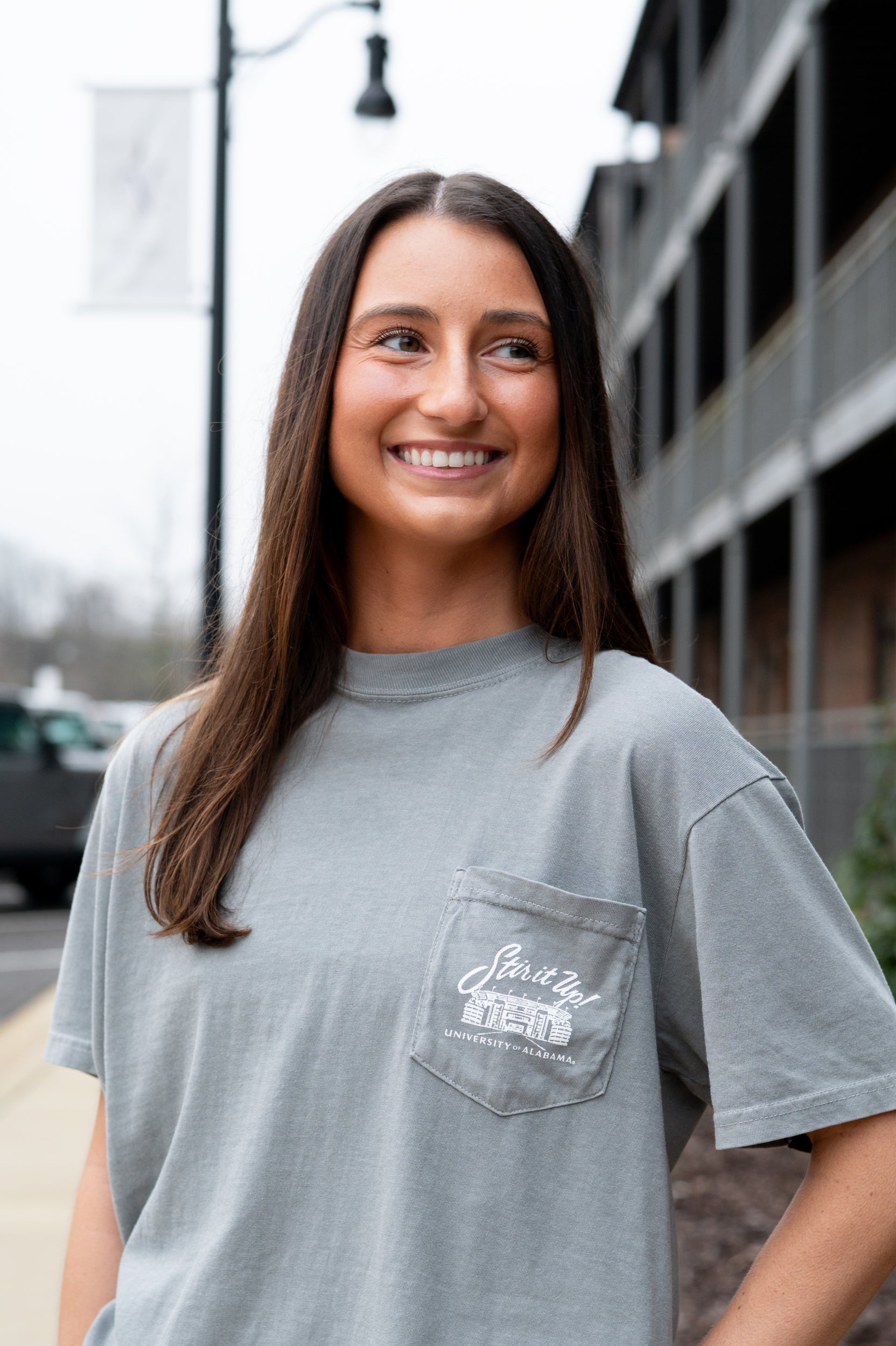 University of Alabama Grey T-Shirt Pocket Design with White text “stir it up” over the Bryant-Denny Stadium
