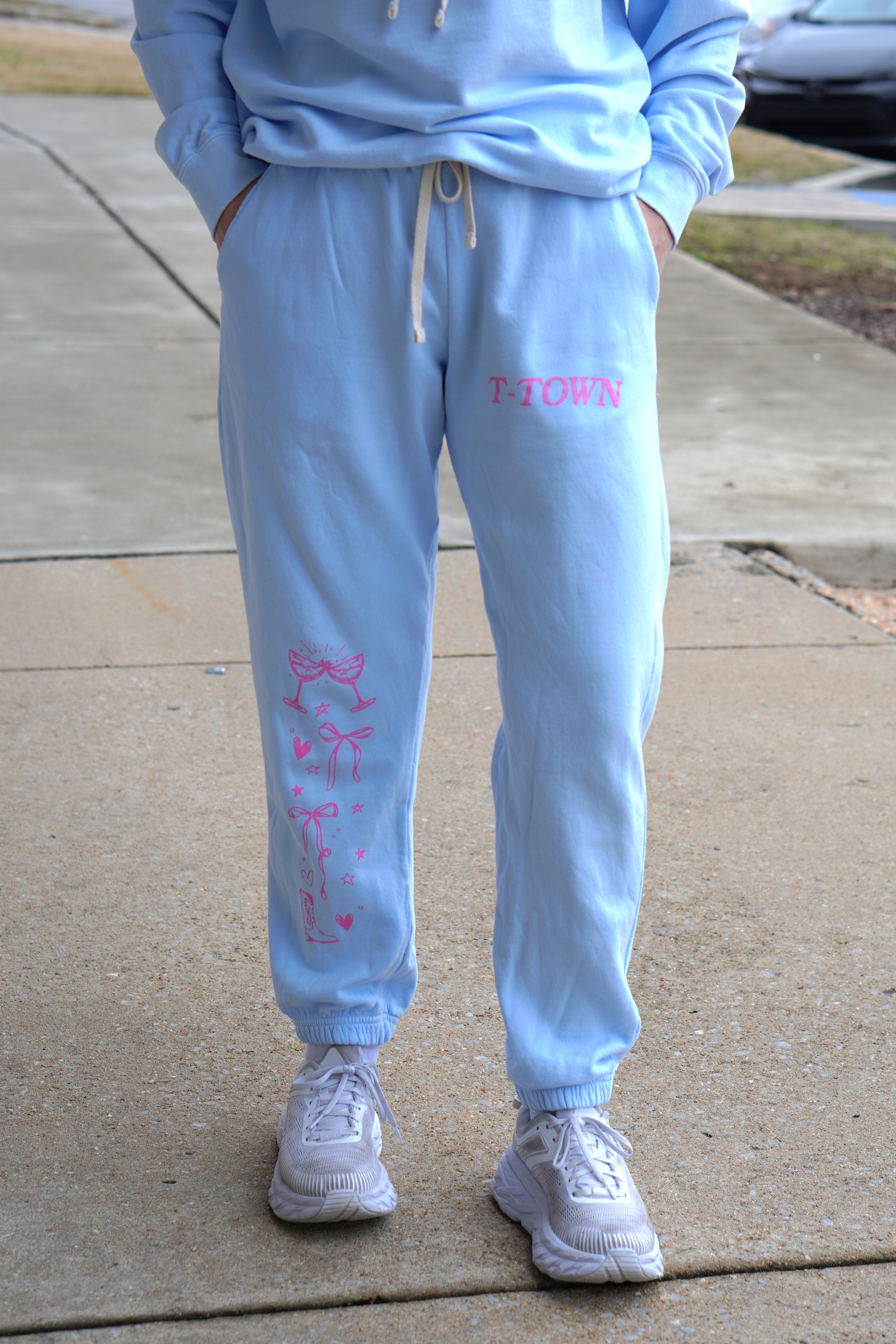 Light Blue T-Town Lifestyle Ladies' Sweatpants with Pink bows hearts, and stars surrounding Pink text "T-TOWN”