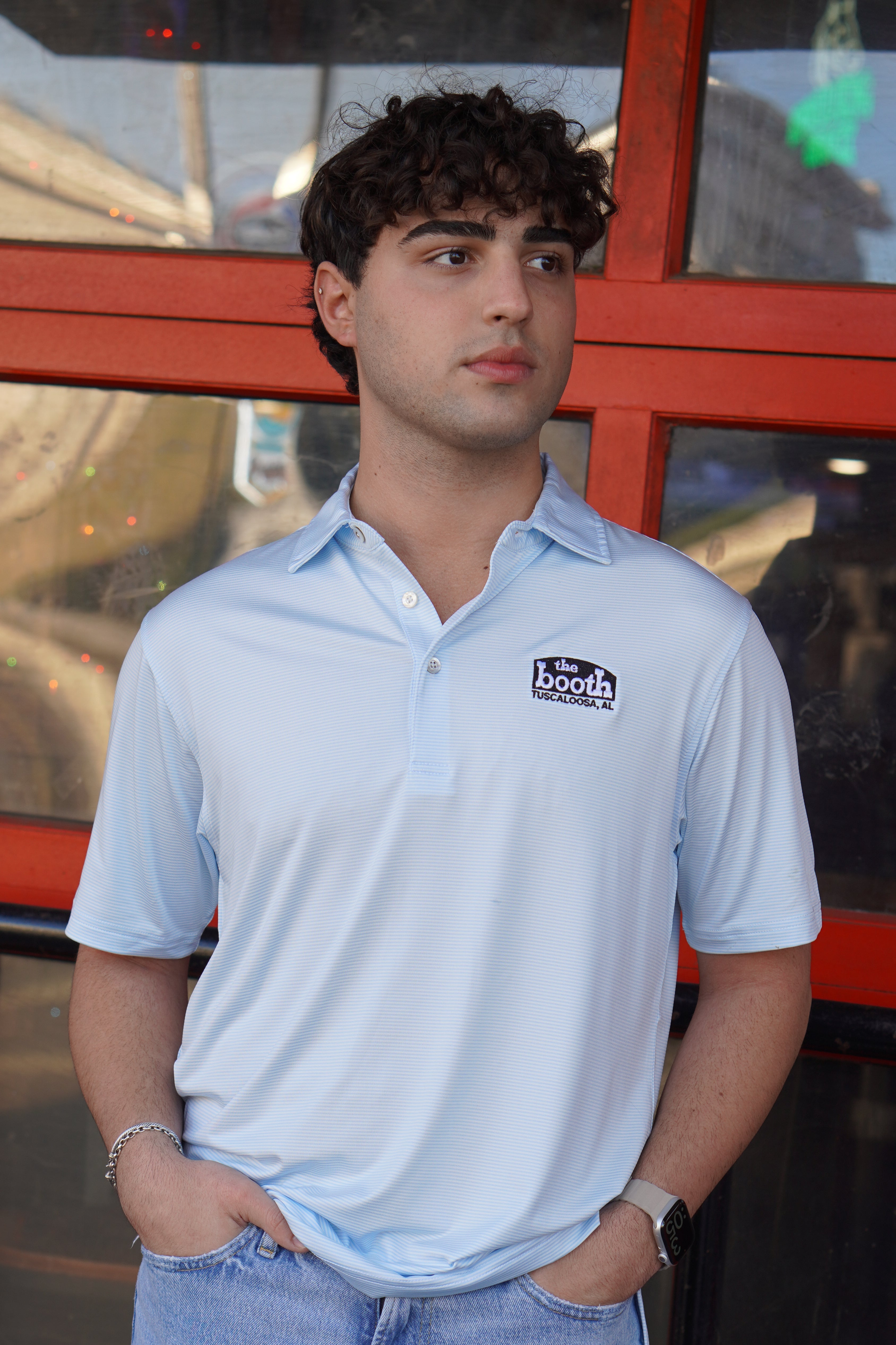 The Booth Light Blue Stripe Men’s Polo with The Booth Logo embroidered on the chest