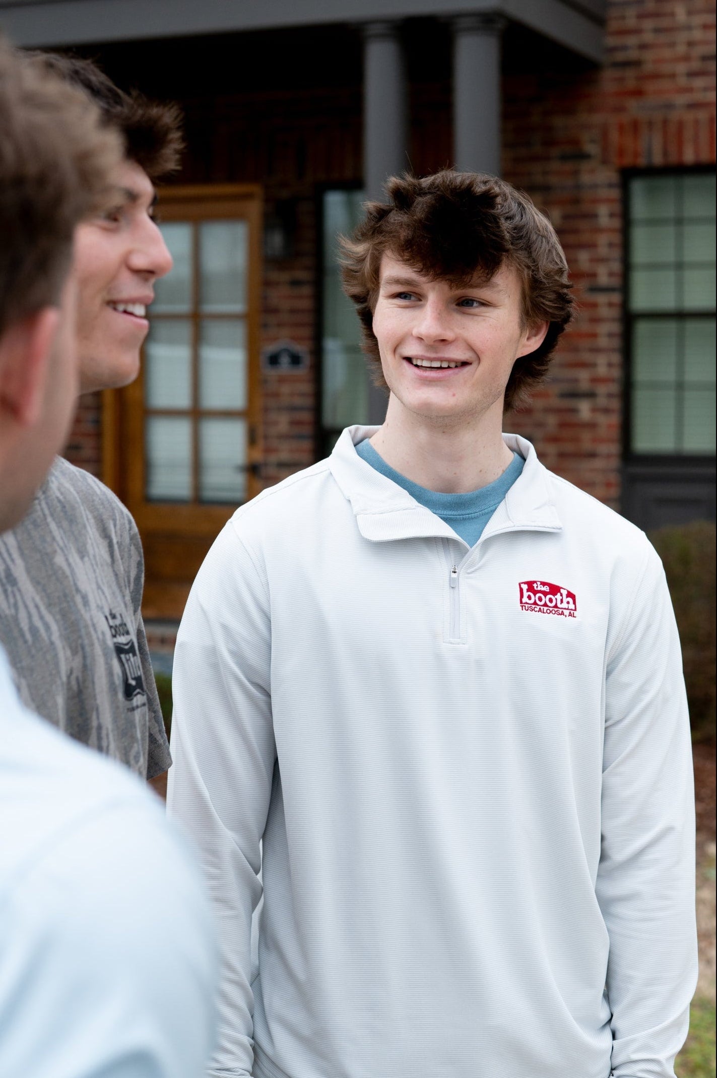 The Booth Light Blue Stripe Men’s Pullover with a Red The Booth Logo embroidered on the chest