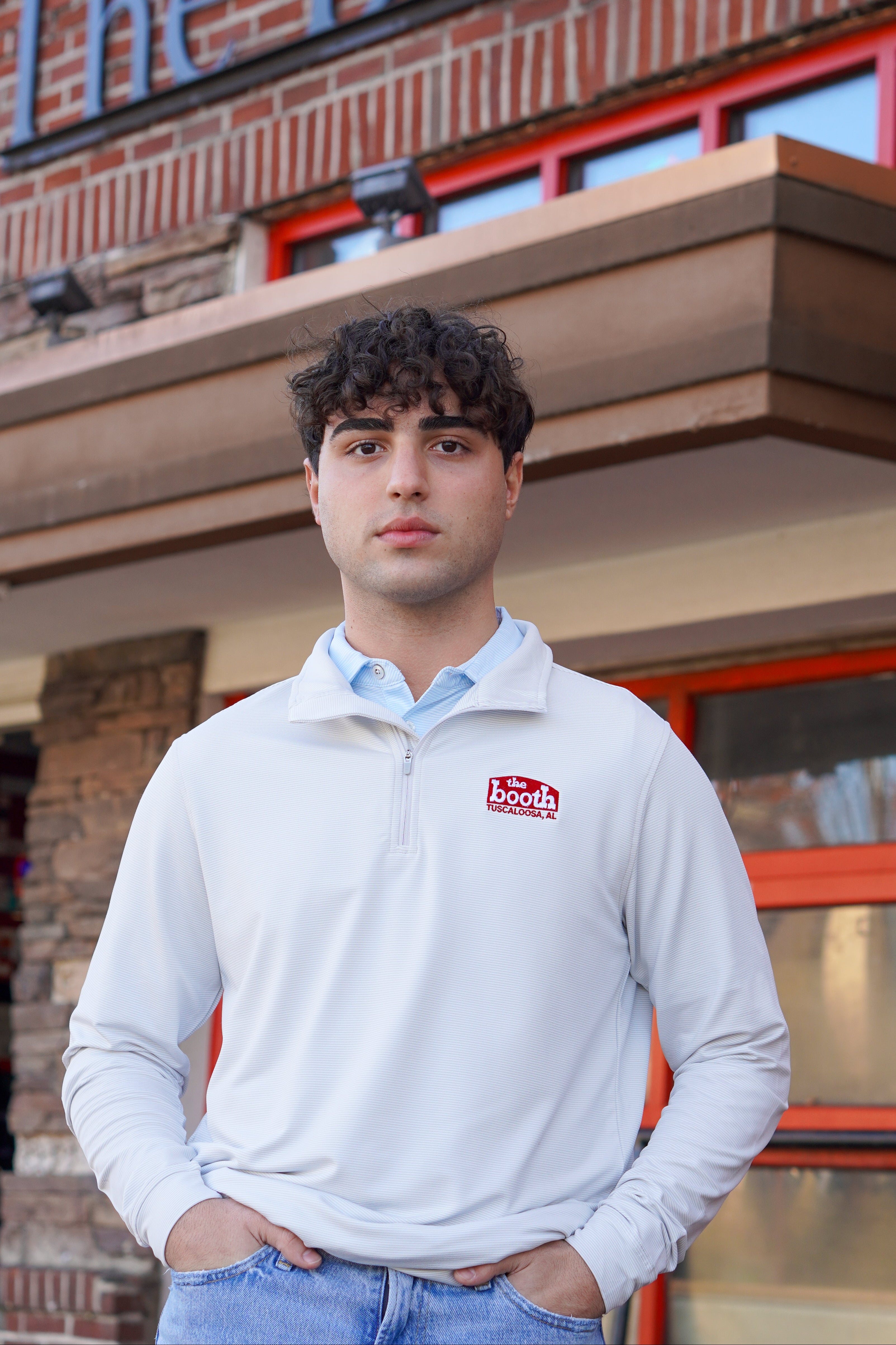 The Booth Light Blue Stripe Men’s Pullover with a Red The Booth Logo embroidered on the chest