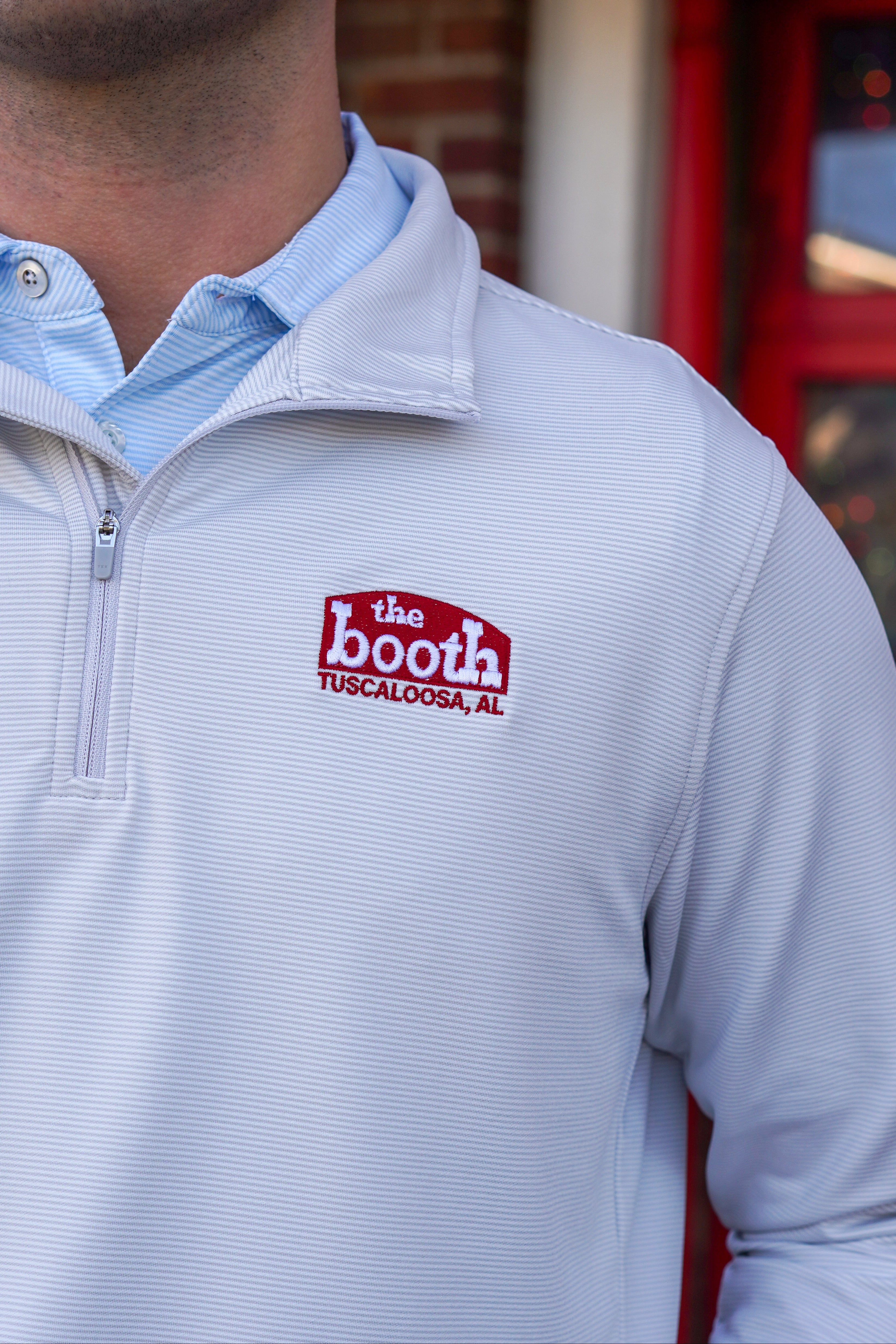 The Booth Light Blue Stripe Men’s Pullover with a Red The Booth Logo embroidered on the chest