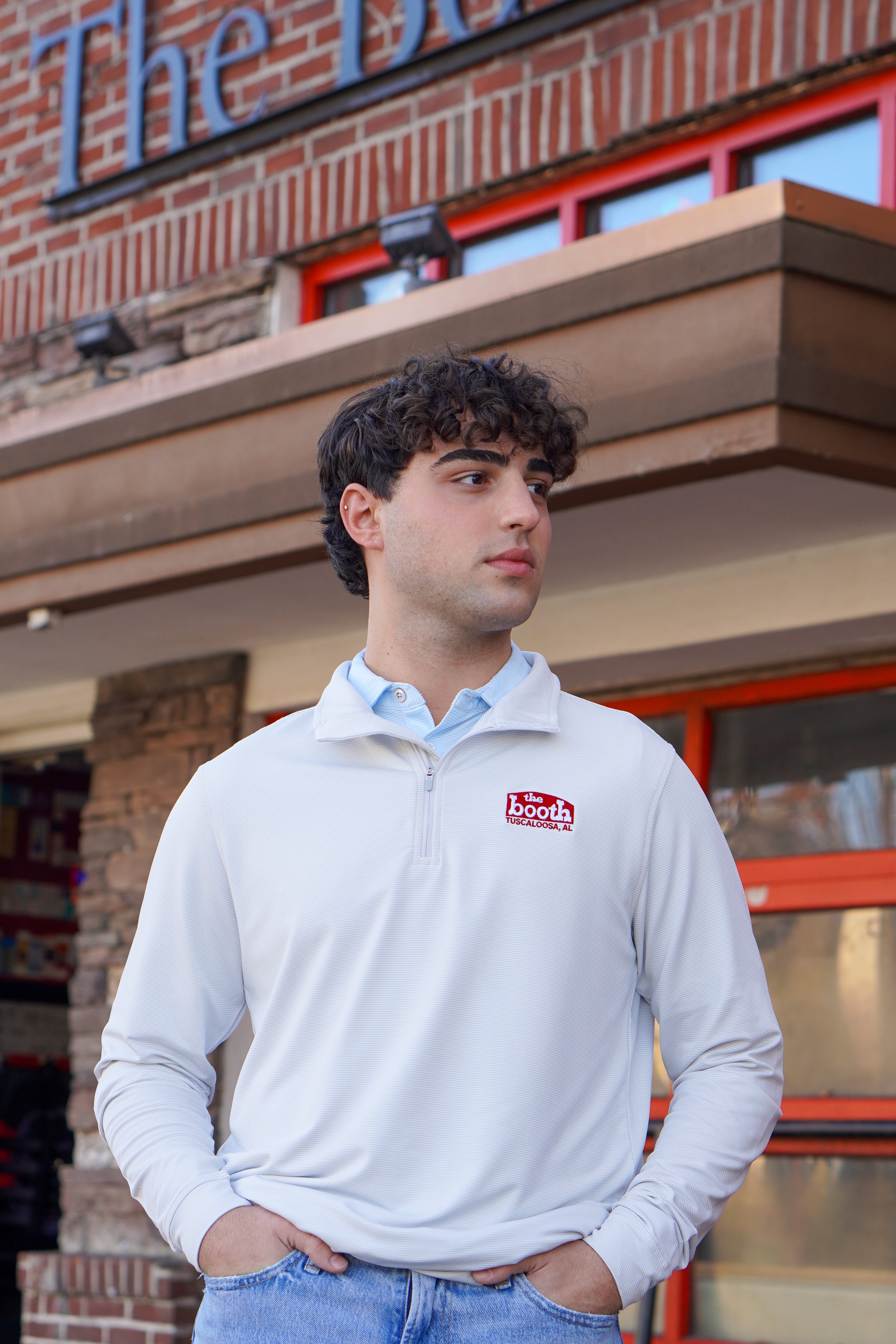 The Booth Light Blue Stripe Men’s Pullover with a Red The Booth Logo embroidered on the chest