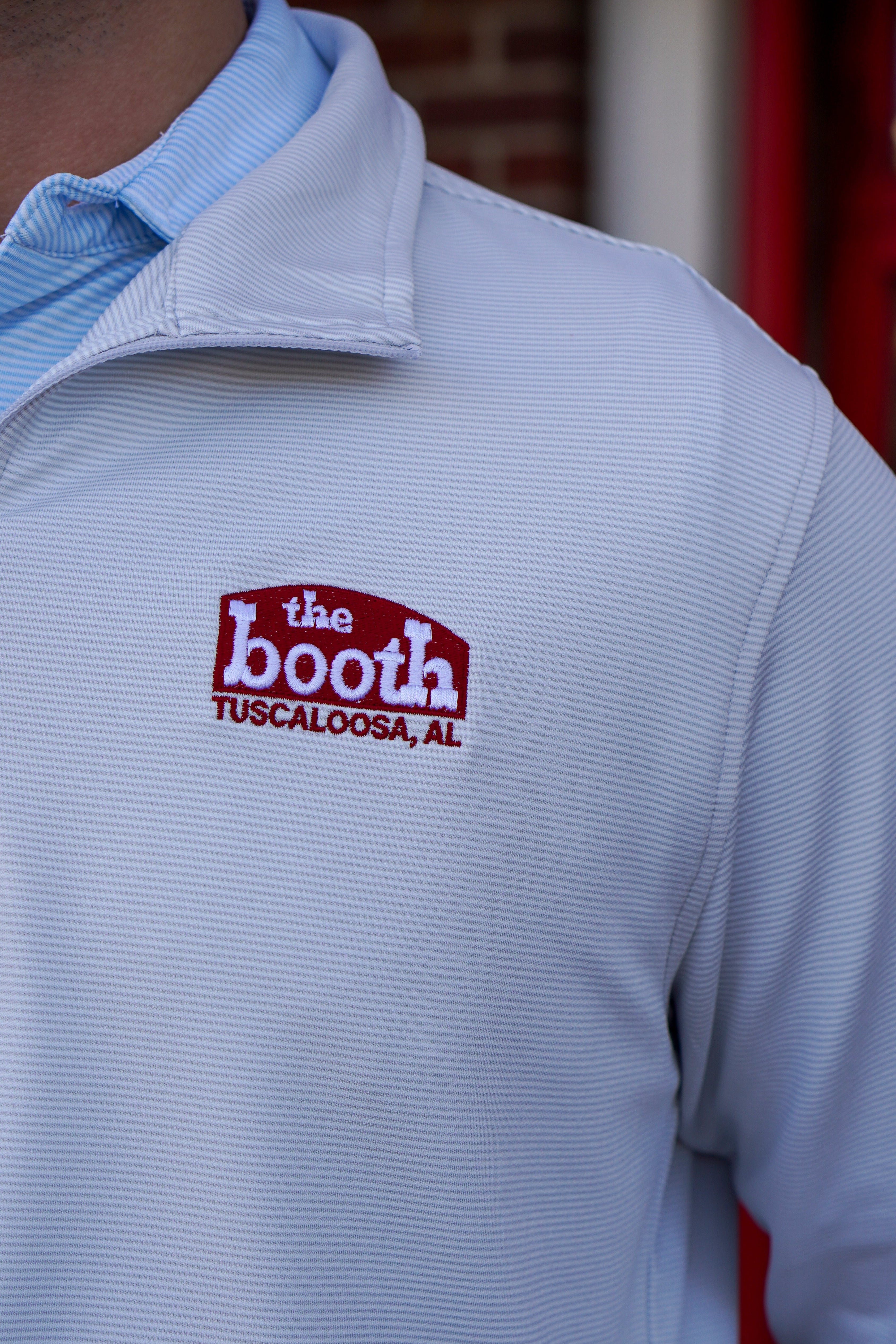 The Booth Light Blue Stripe Men’s Pullover with a Red The Booth Logo embroidered on the chest