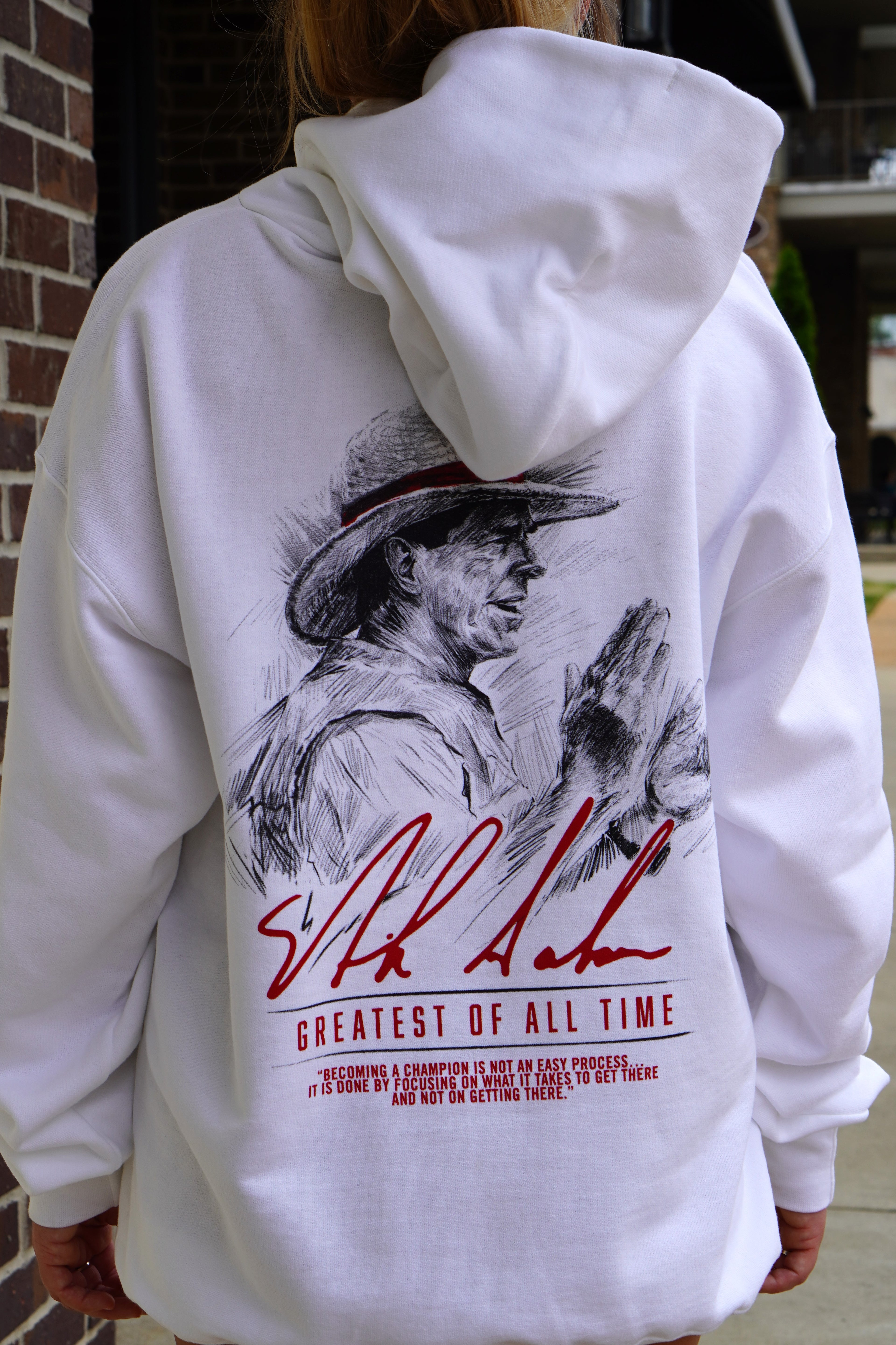 University of Alabama White Hanes Hoodie with an illustration of Nick Saban above his signature and Red text "Greatest Of All Time" 