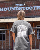 The Houndstooth Dark Grey T-Shirt with White text "The Houndstooth" above an image of a Beagle laying inside of a doghouse
