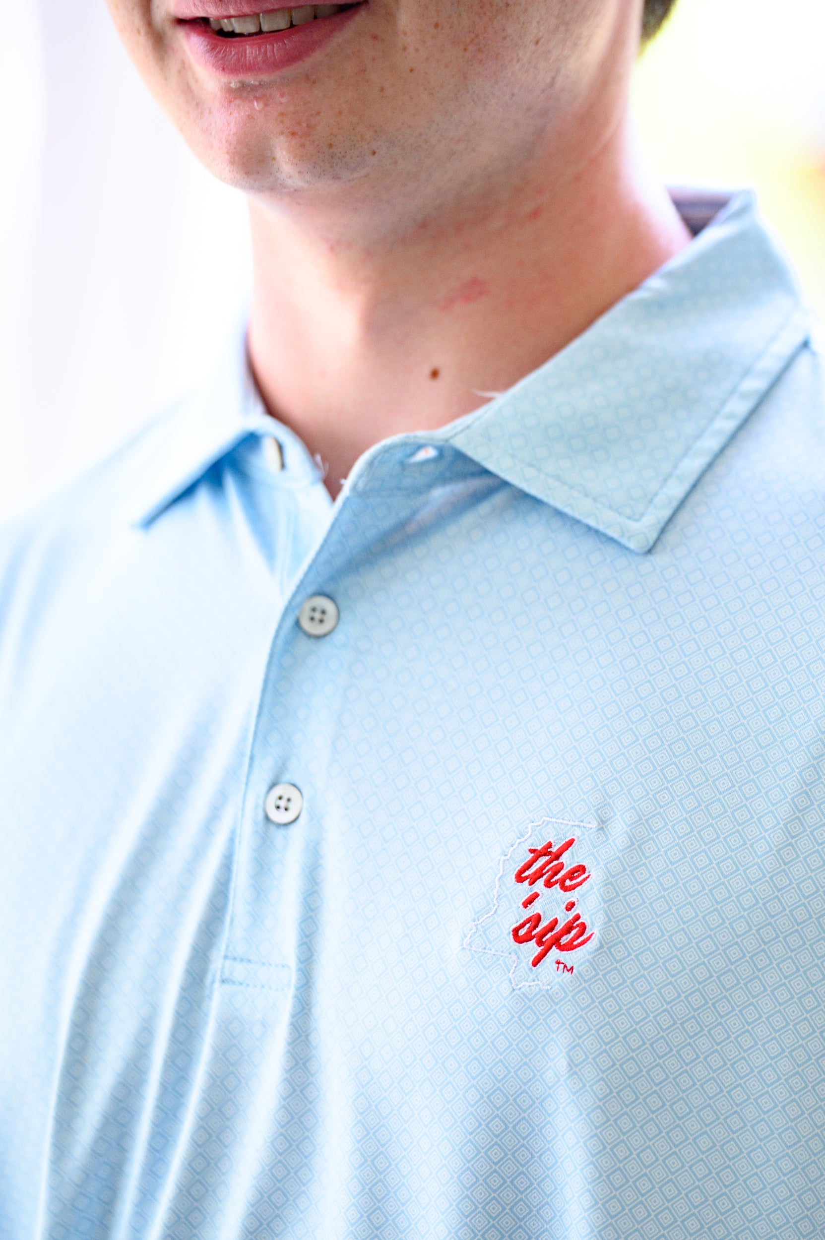Ole Miss Blue Men’s Diamond Polo with an embroidered White outline of Mississippi and Red script “the ‘Sip”