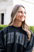 University of Alabama The Tide Varsity Ladies’ Black Independent Sweatshirt with an oversized The Tide print. 