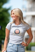 Gray Title Town Baby Tee with distressed Navy text "Tuscaloosa" above the Title Town emblem, which features Gold, Navy, and Red circles with text “Title Town” and a bundle of wheat.