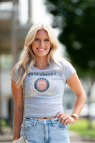 Gray Title Town Baby Tee with distressed Navy text "Tuscaloosa" above the Title Town emblem, which features Gold, Navy, and Red circles with text “Title Town” and a bundle of wheat.